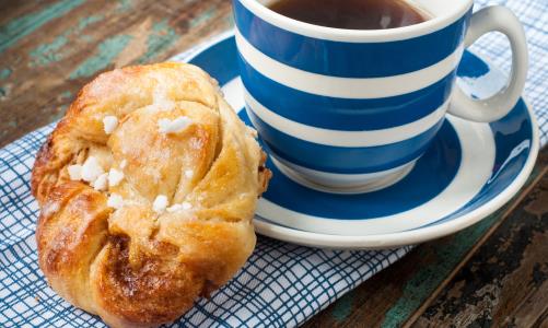 Bilden visar en kaffekopp och en kaka