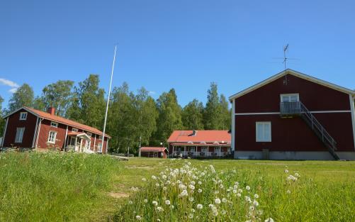 Husen på Kyrkans lägergård med Husmorsvillan till vänster, huvudbyggnaden i mitten och logementet till höger