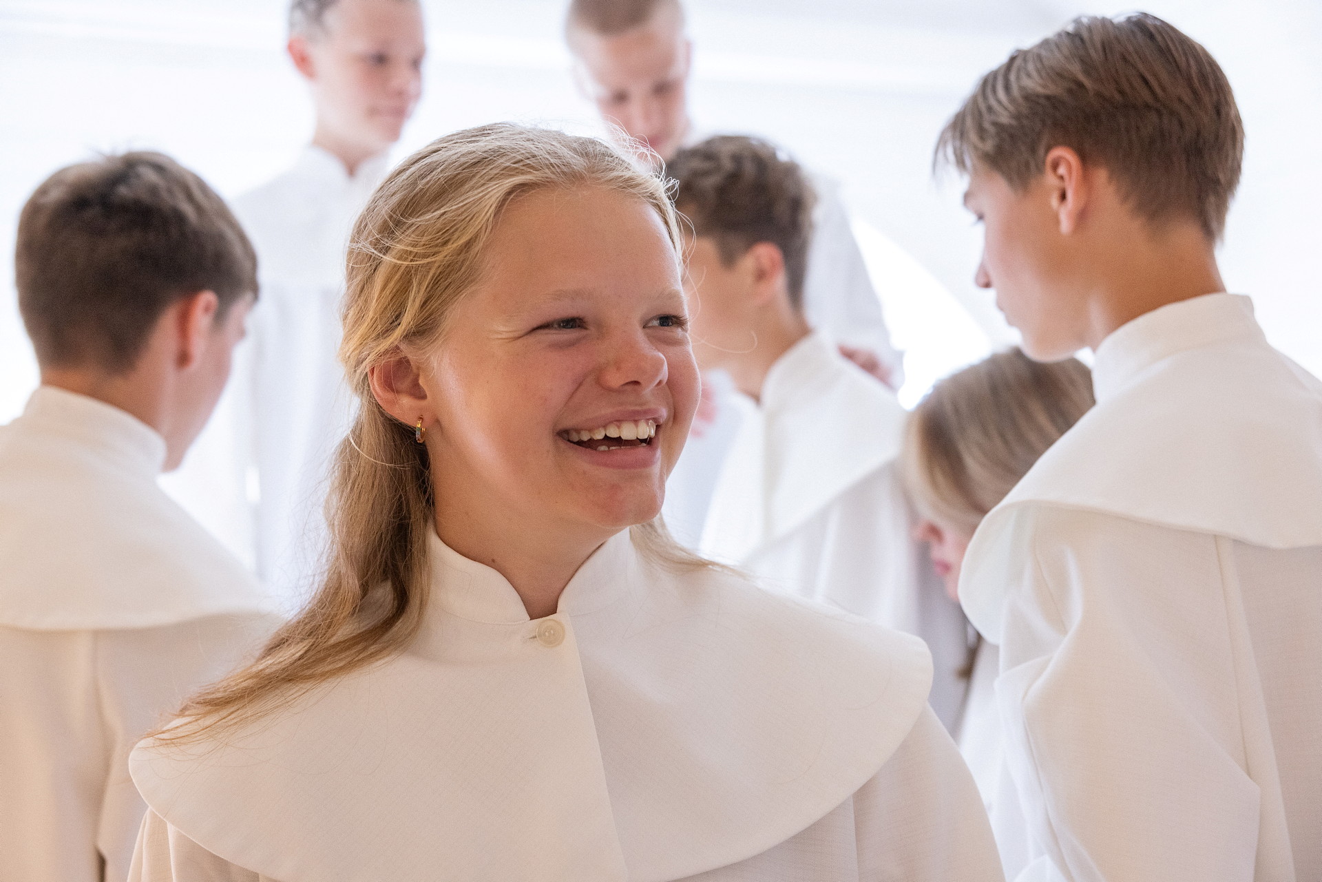 Ungdomar i konfirmandkåpor