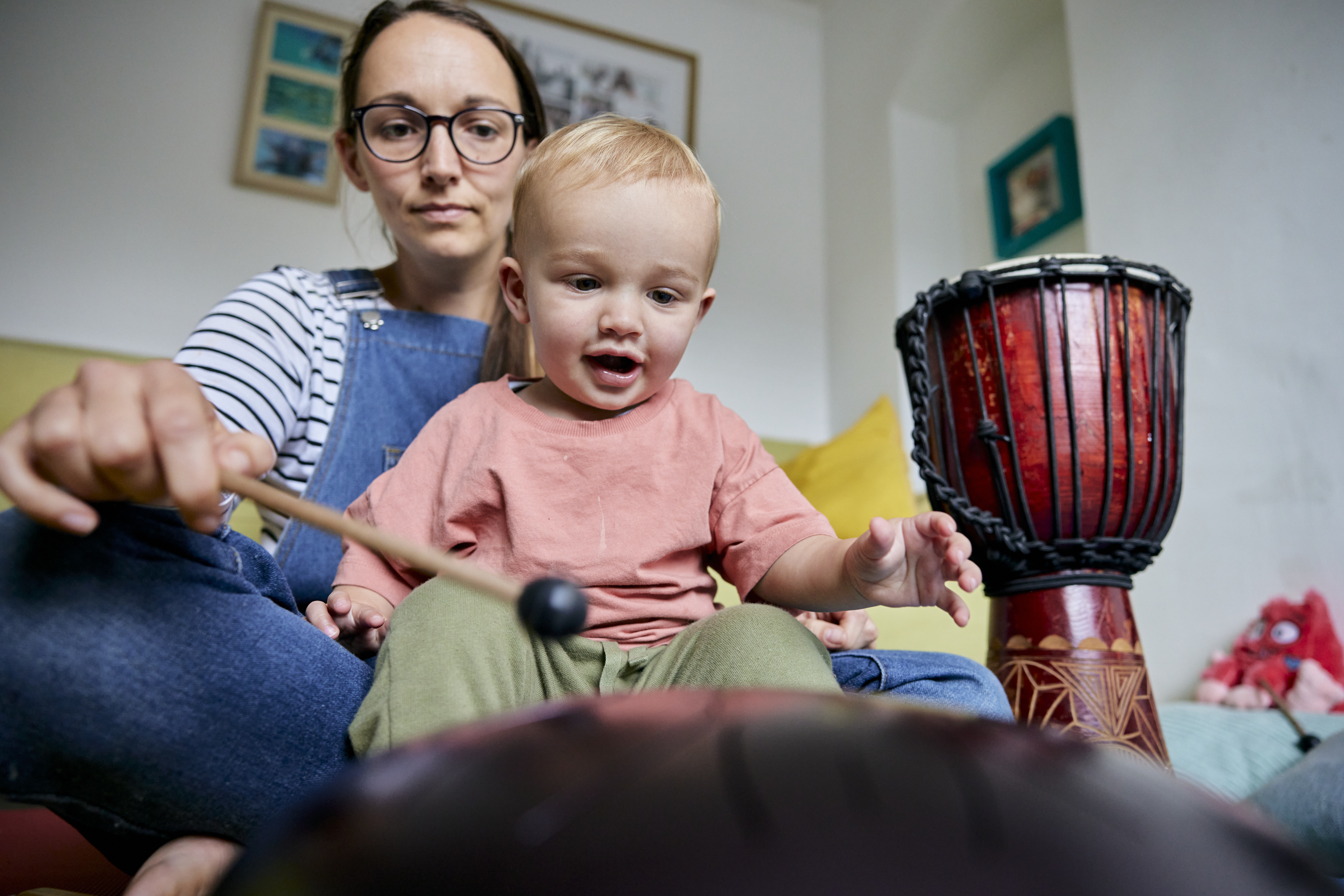 Kvinna och ett spädbarn spelar trumma tillsammans