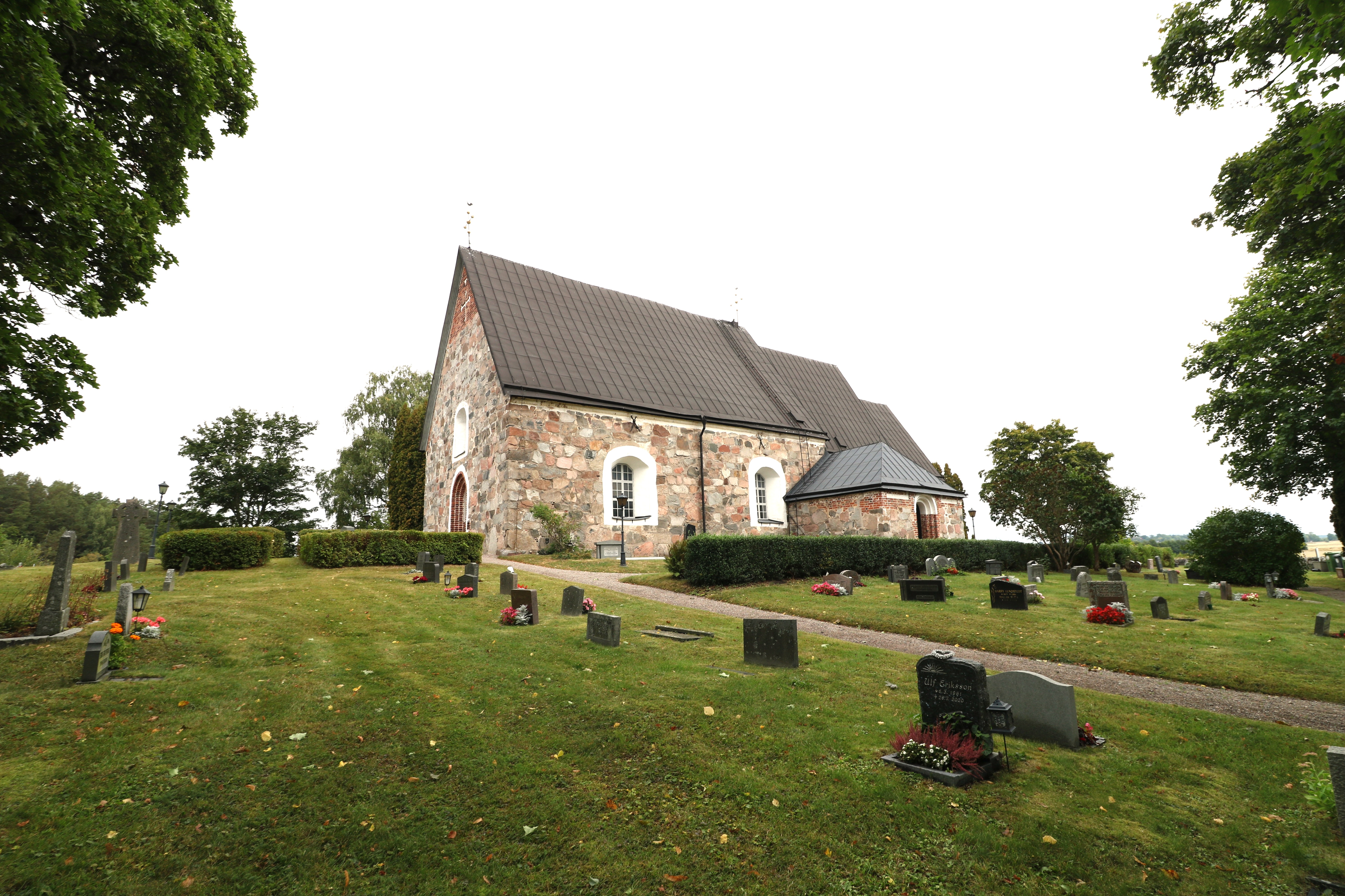 En kyrkogård framför en stenkyrka