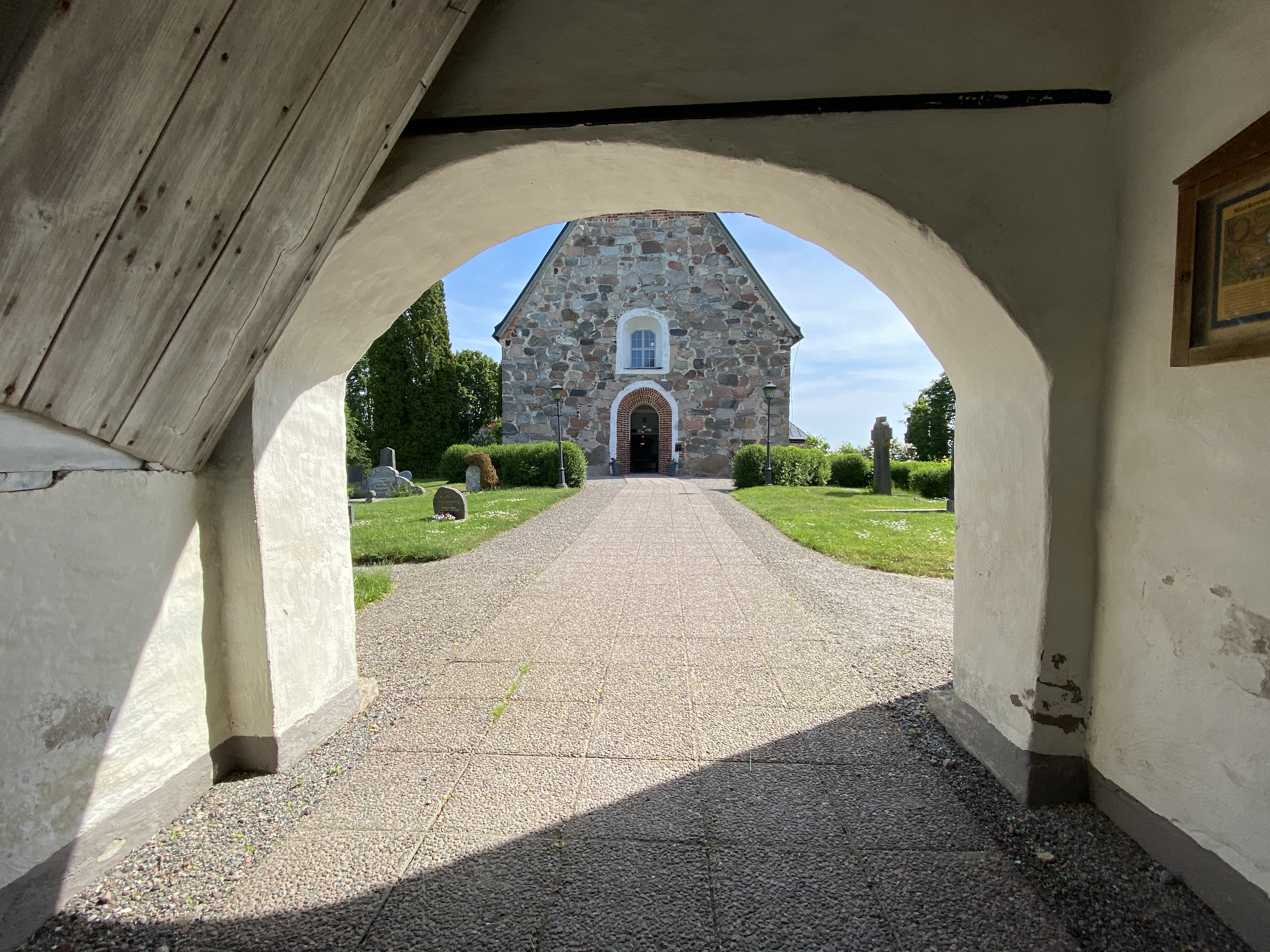 En kyrka syns genom en portöppning.