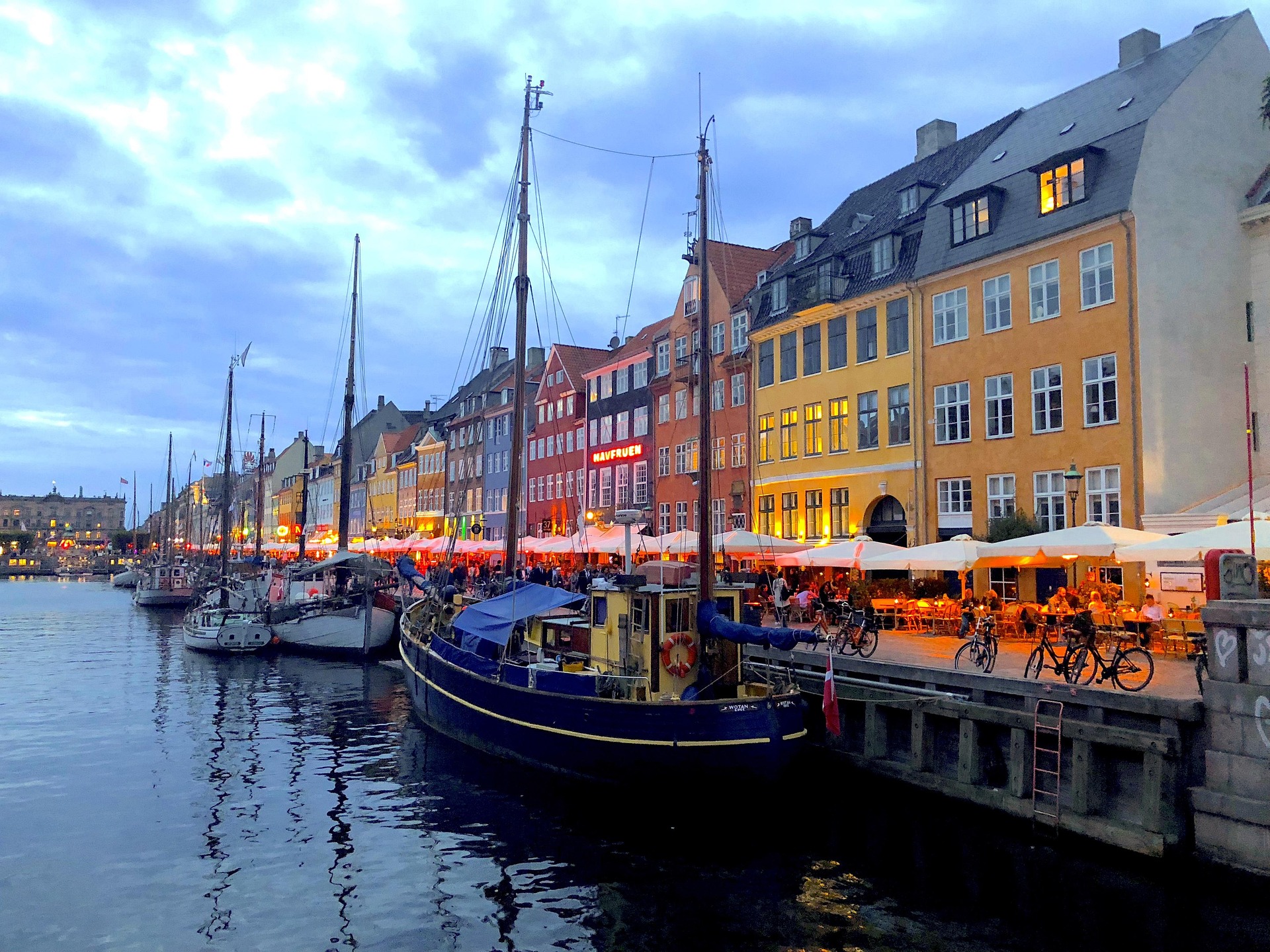 En kaj och hus vid kajen. Båtar ligger förtöjda längs med kajen.