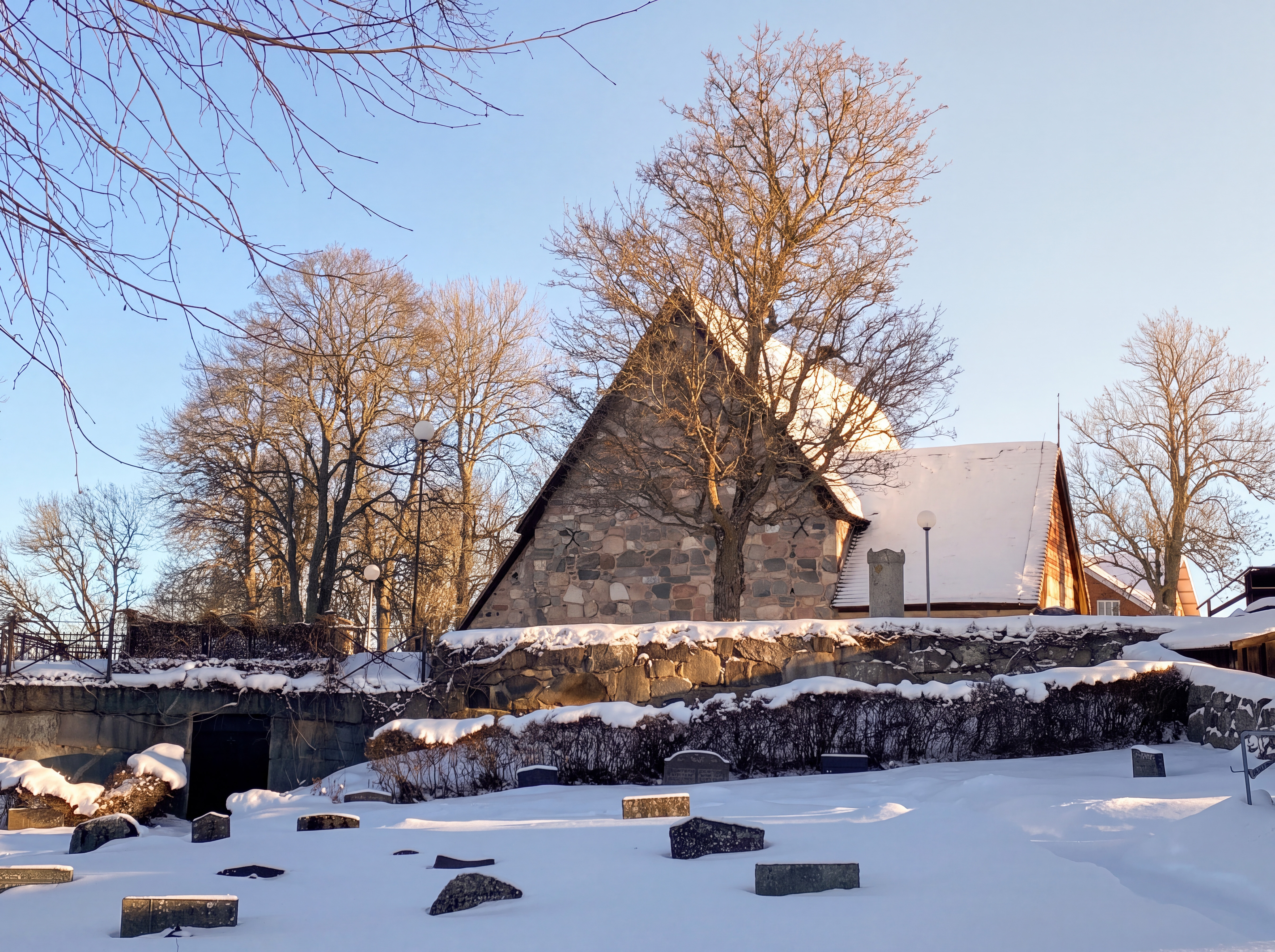 En vy över en kyrkogård i snö och en kyrka i bakgrunden