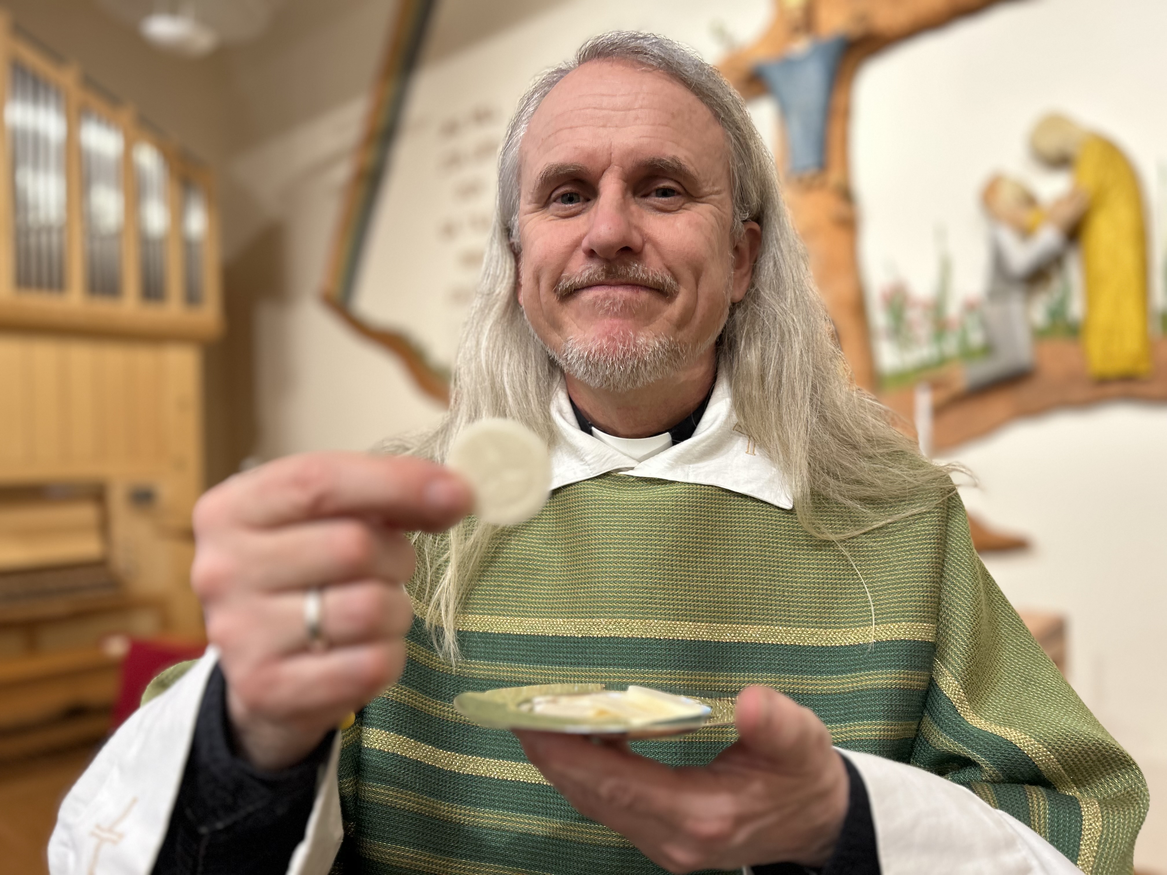 Präst som räcker fram nattvard