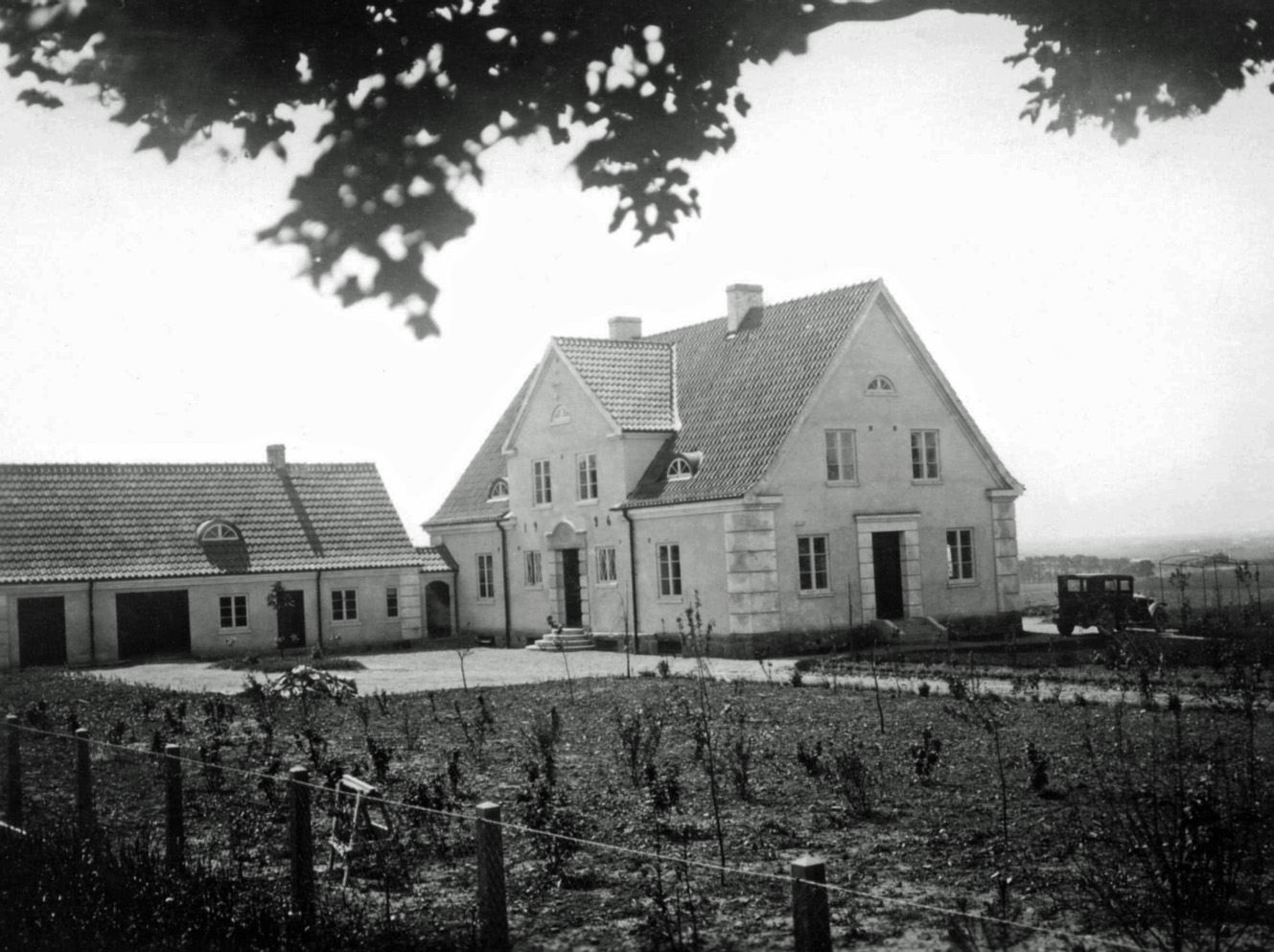 Prästgård och uthus från 1920-talet med nya trädplanteringar. Separat entré in till pastorsexpeditionen finns på gaveln. Från Emil Lundblads fotosamling. P-O Bengtsson.