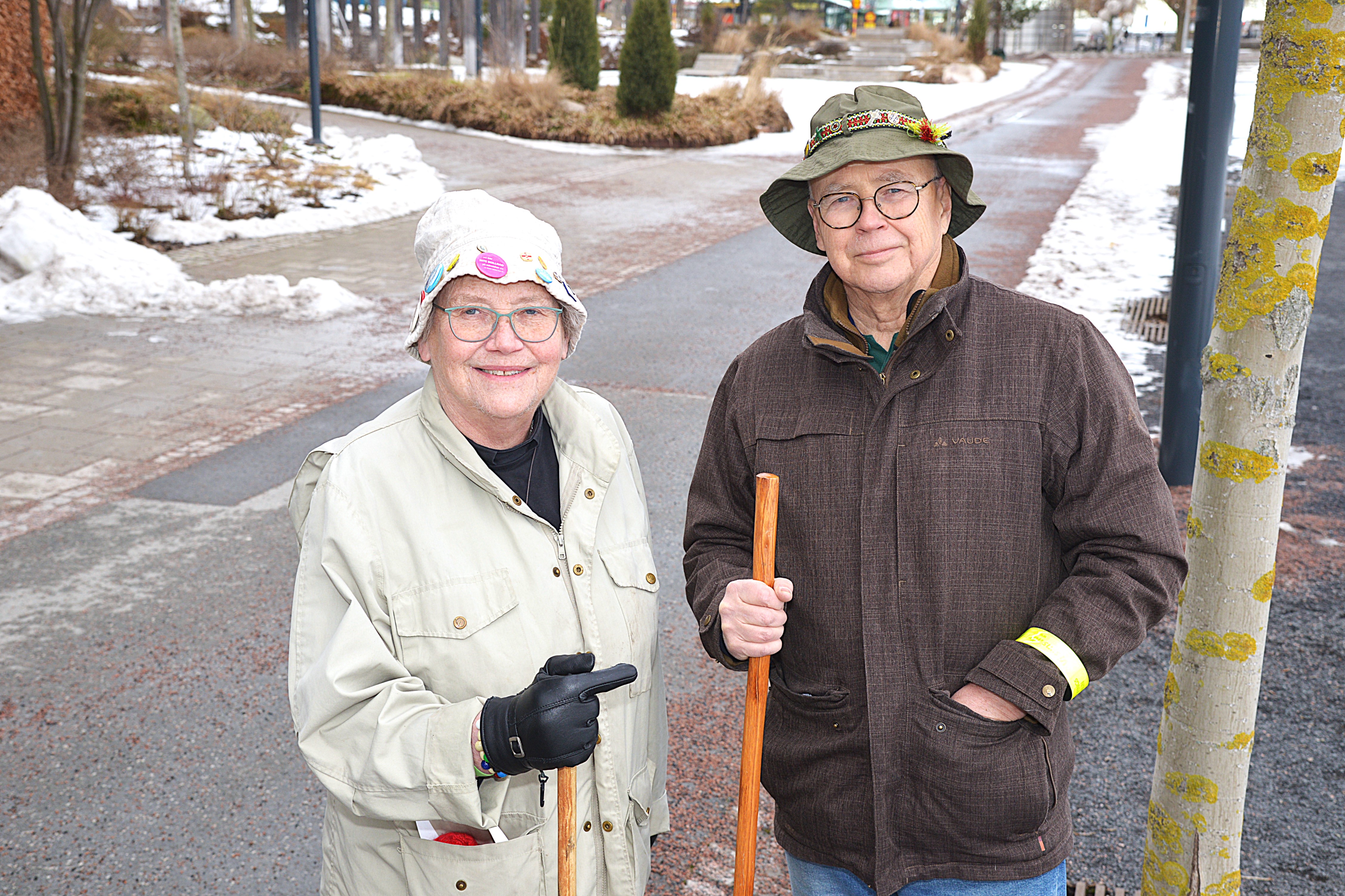 En kvinna och en man står med vandringsstavar