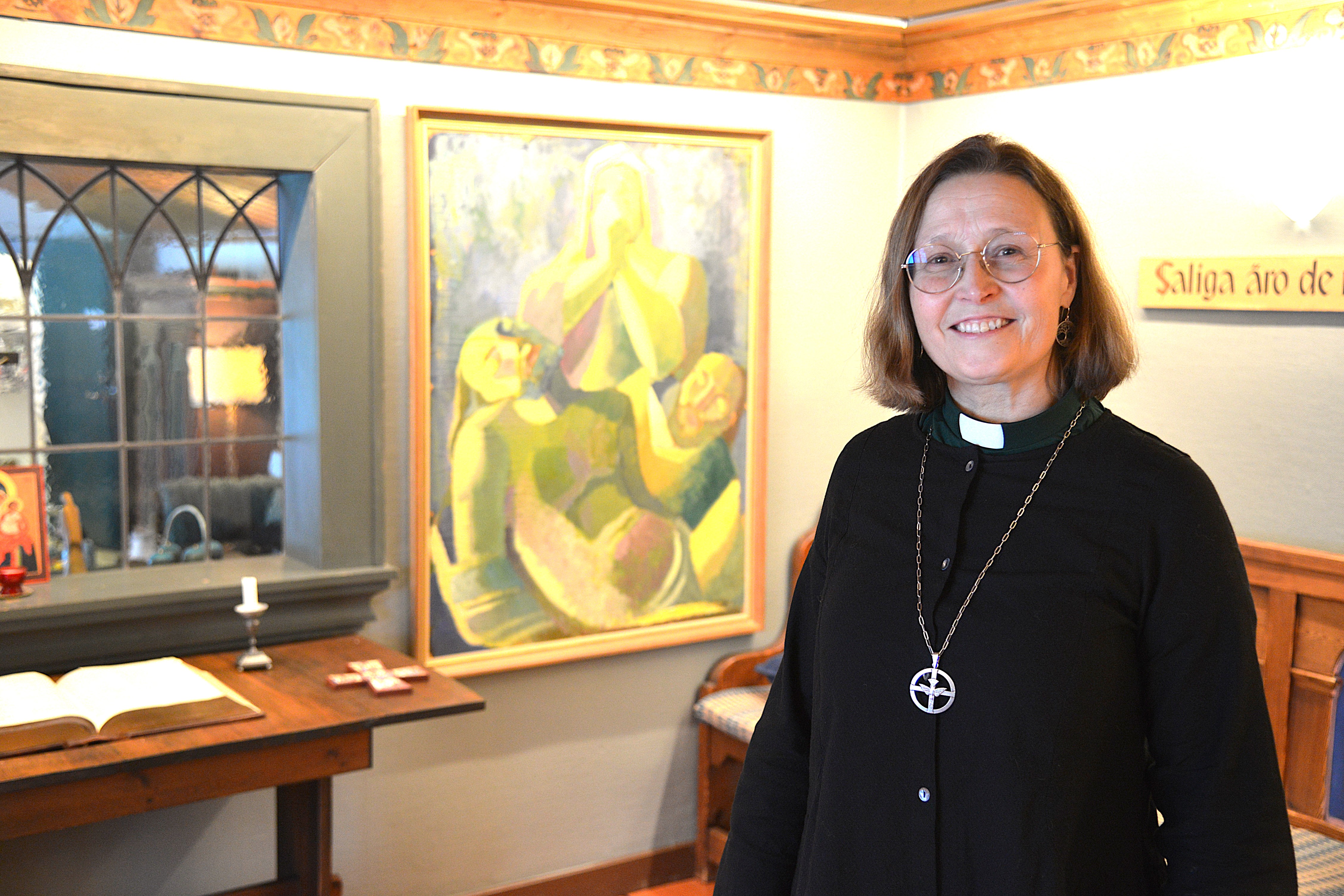 En kvinna i svarta kläder står i ett rum