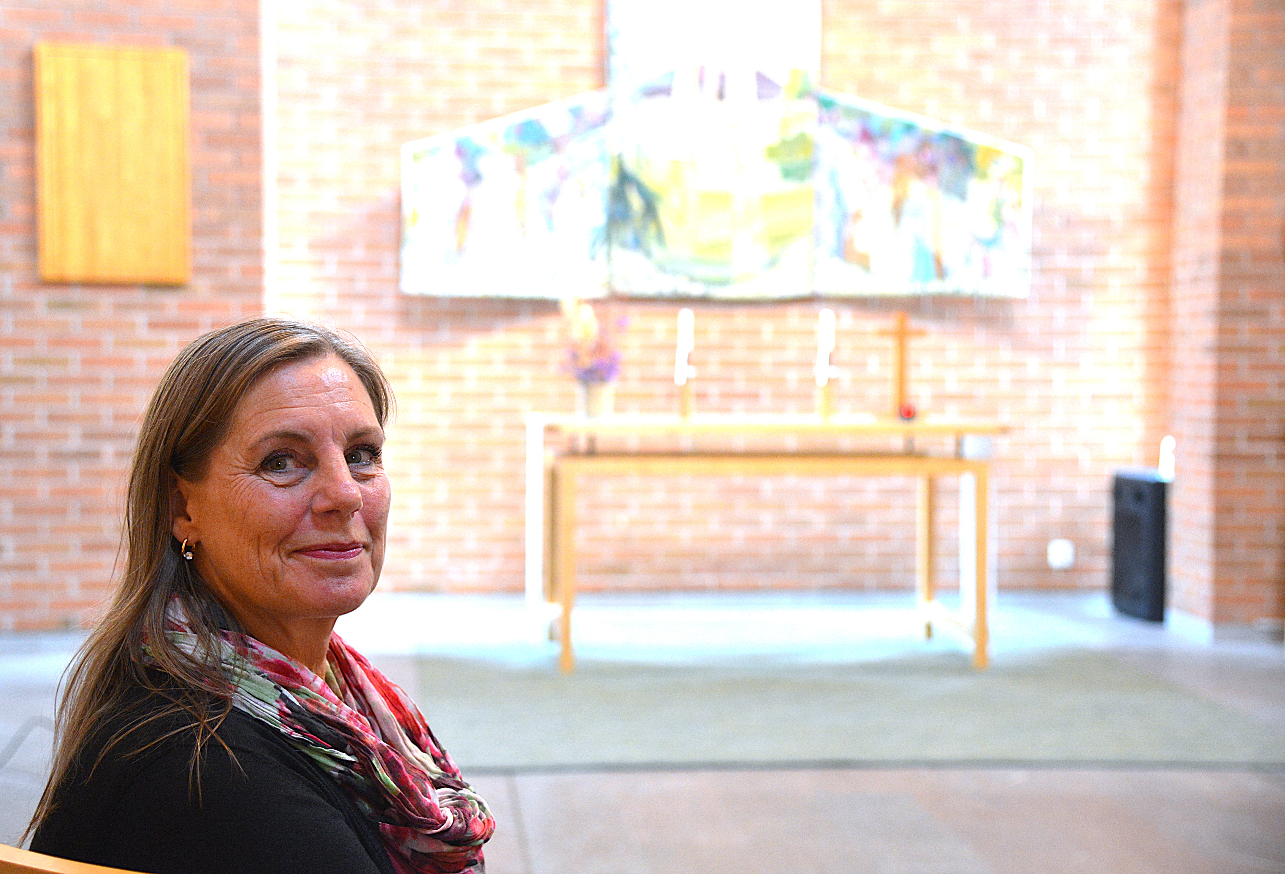 En kvinna sitter på en stol i en kyrksal