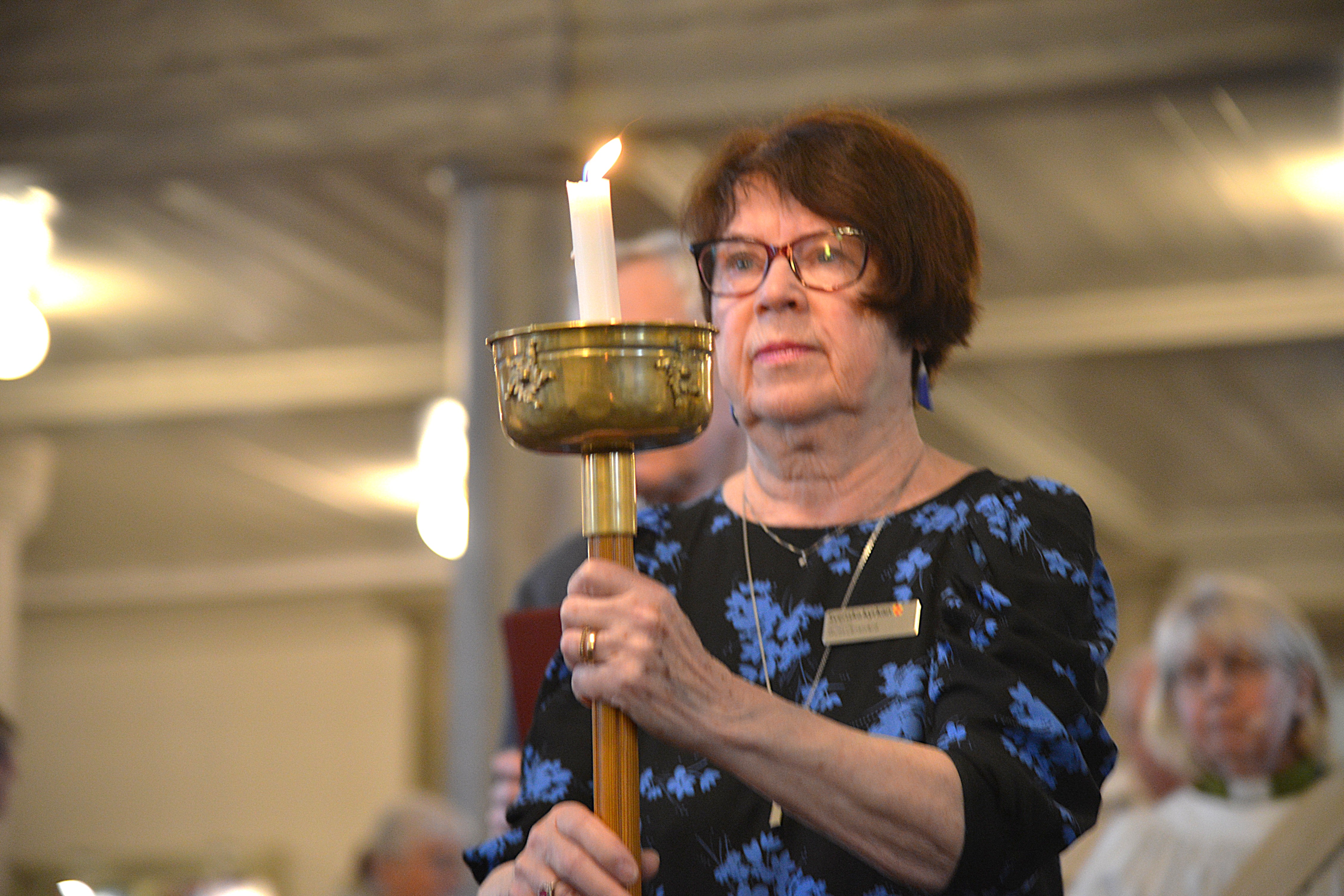 En kvinna går med ett ljus i handen