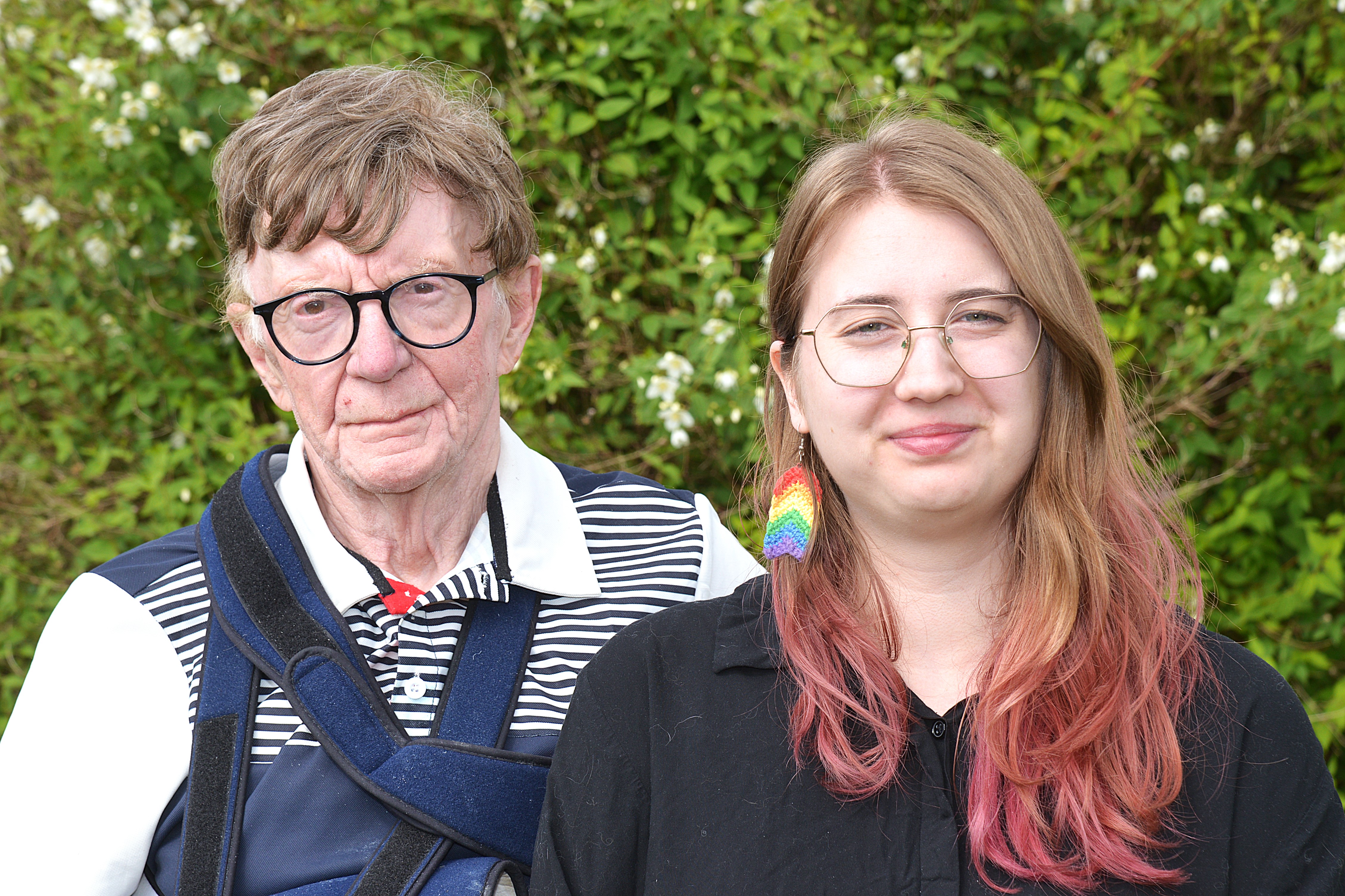 En man och en kvinna står i en trädgård