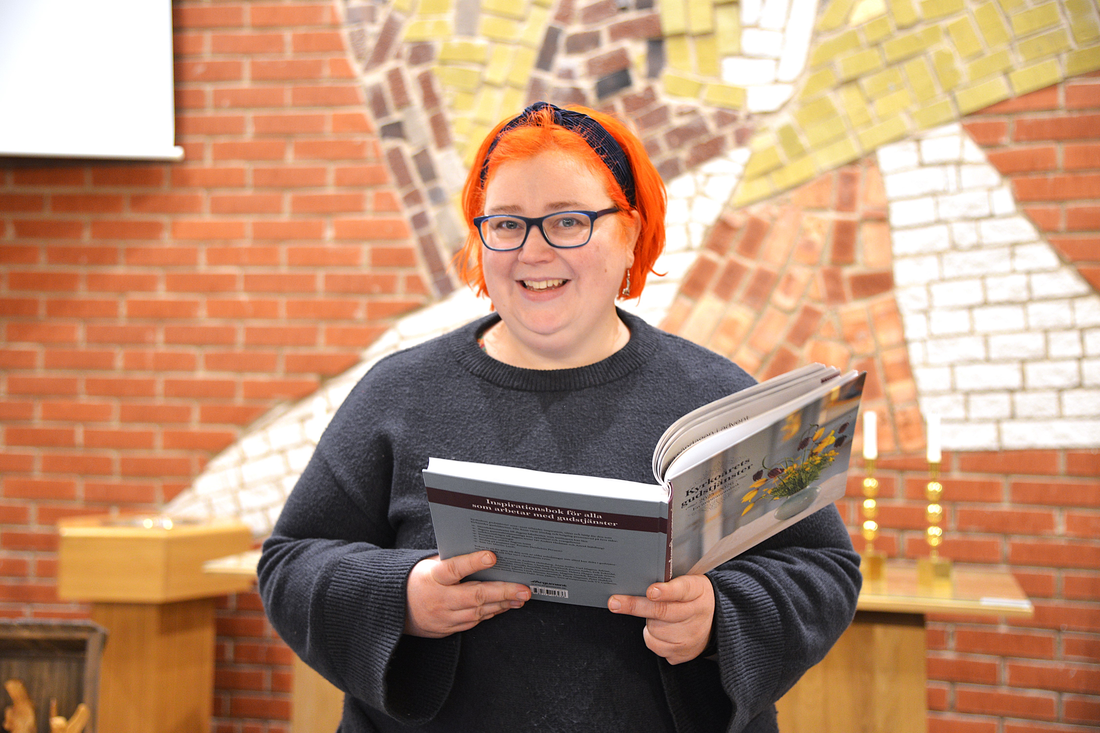 En kvinna står vid ett altare med en bok i handen