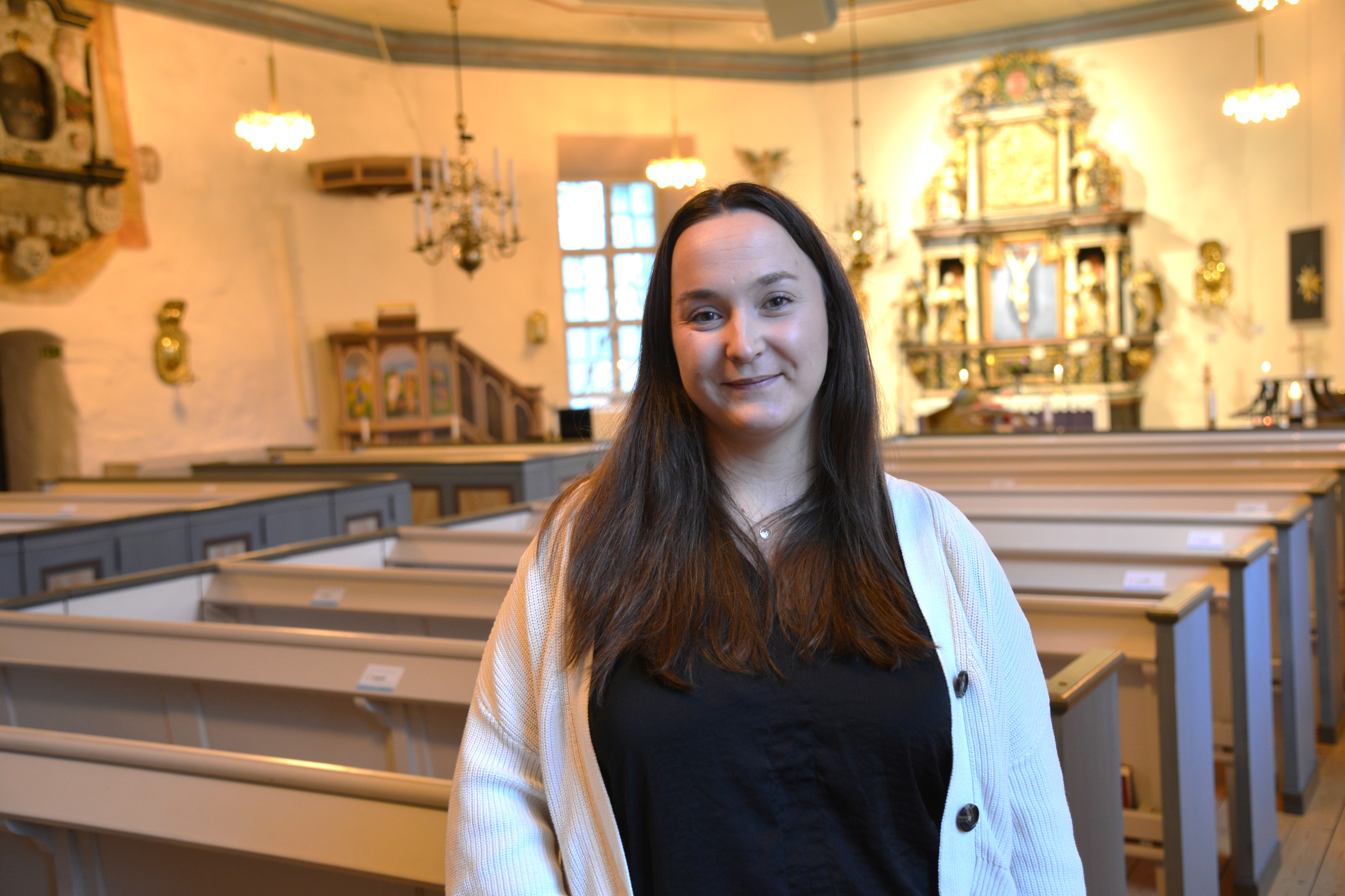 En kvinna står i en kyrksal
