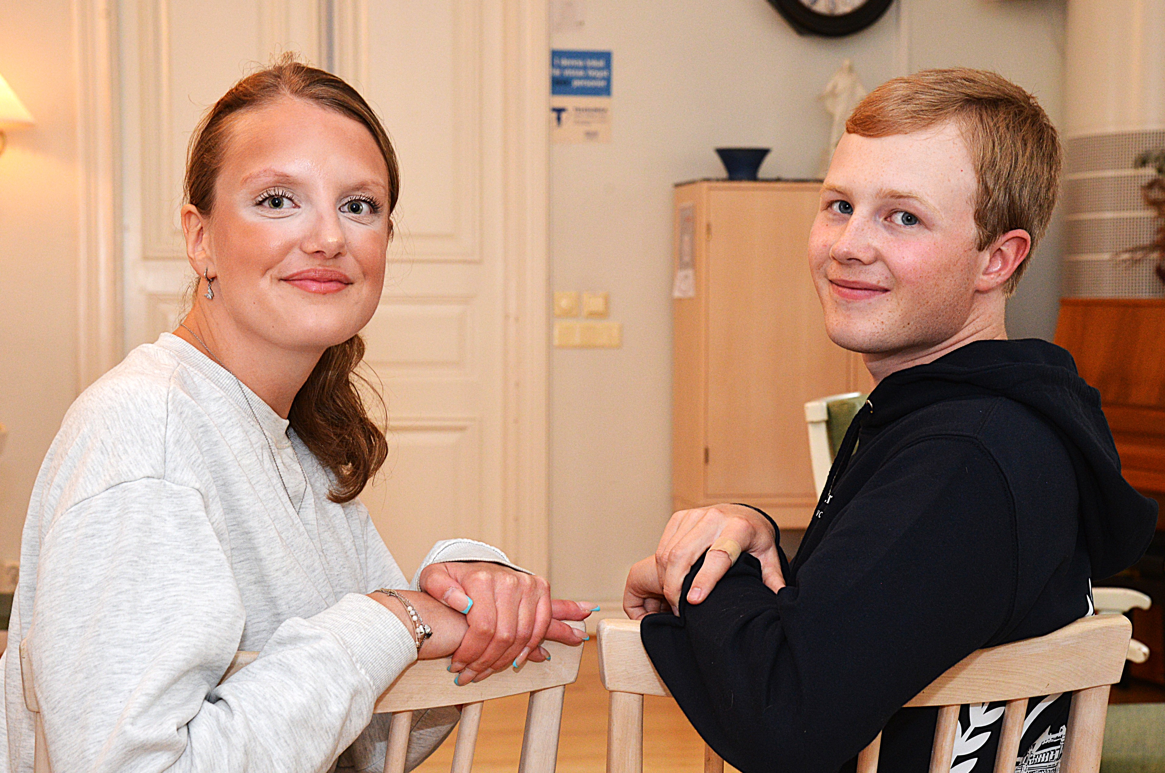 En tjej och en killa sitter på varsin stol och tittar upp