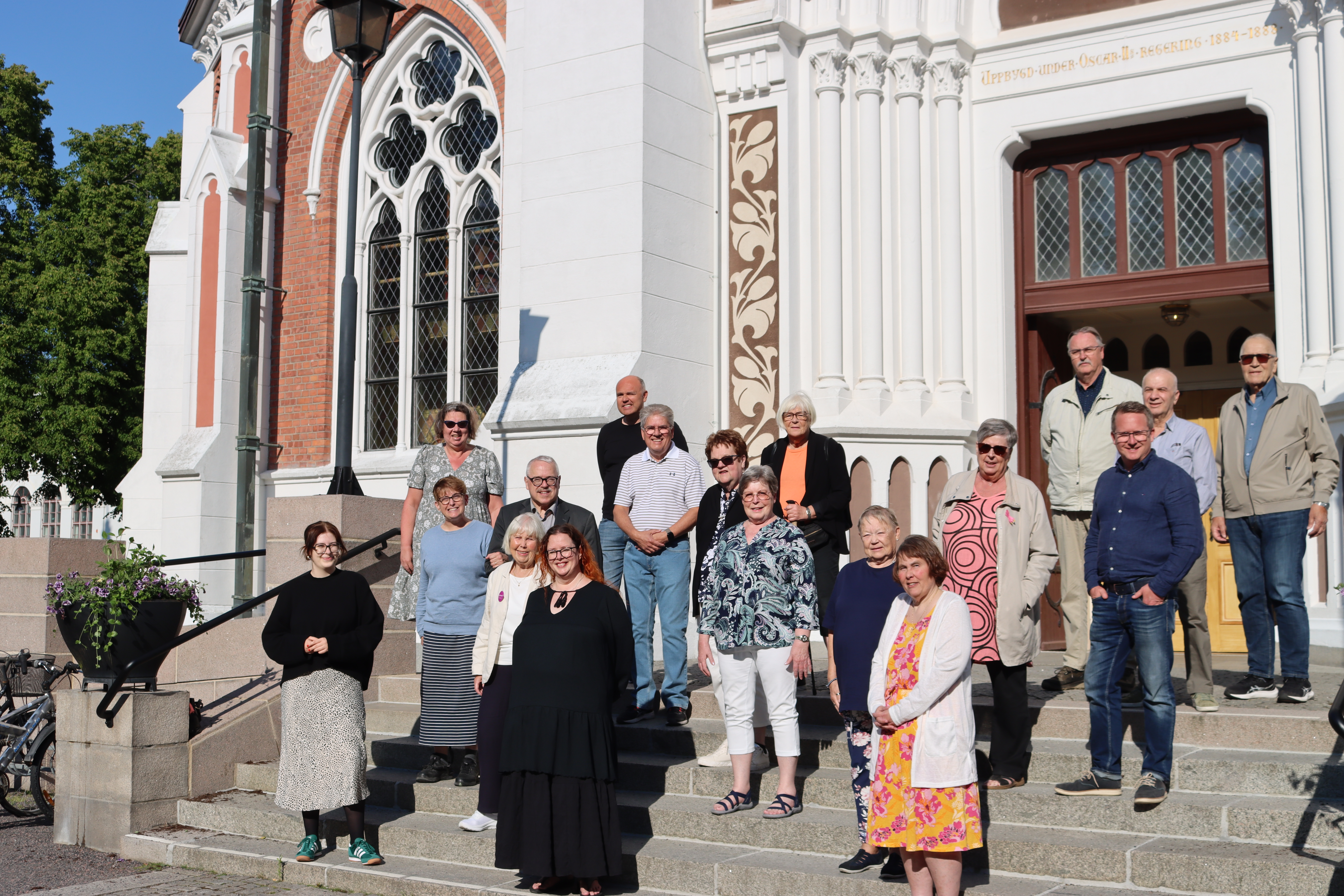 En grupp människor står på en kyrktrappa