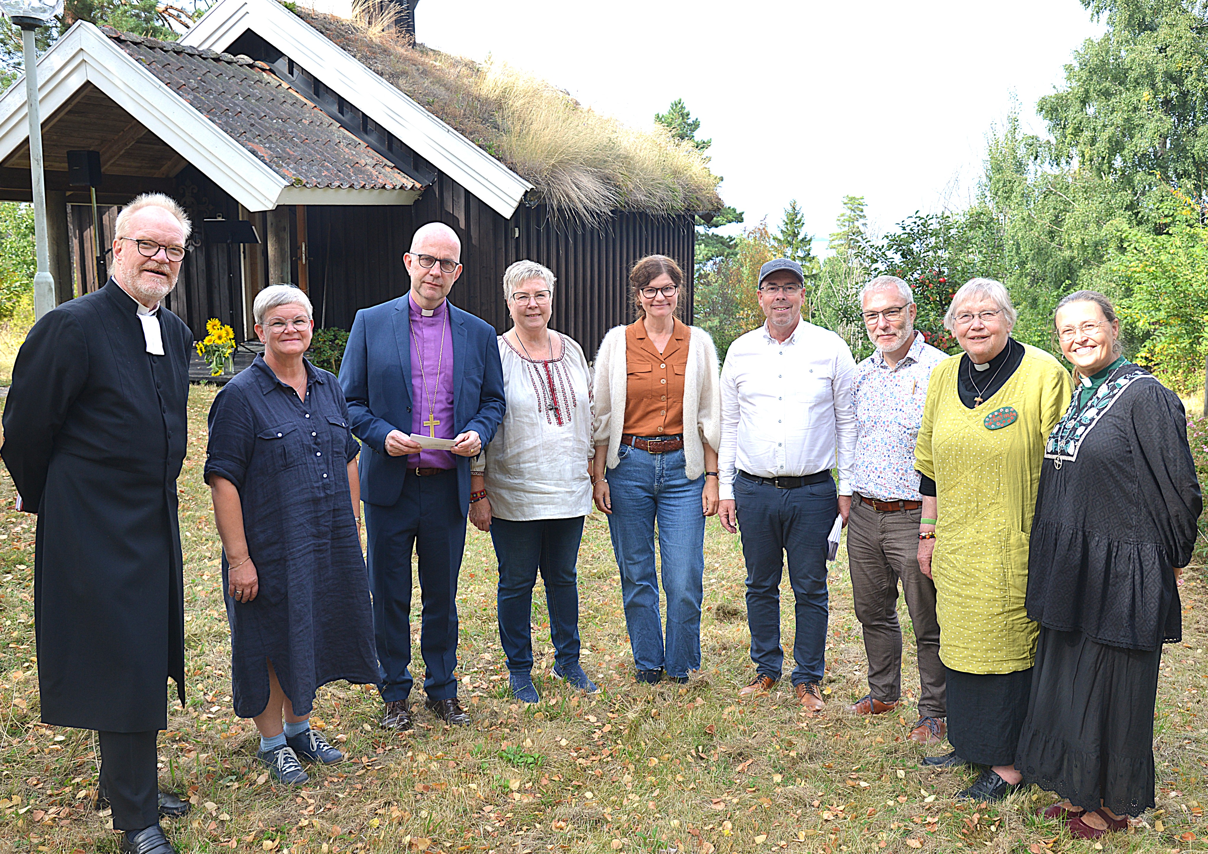 En gruppbild framför ett litet kapell