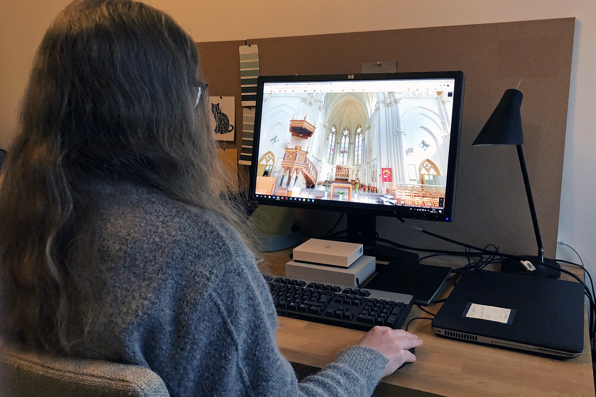 Kvinna sitter framför datorskärm som visar en virtuell rundtur av Sofiakyrkan.