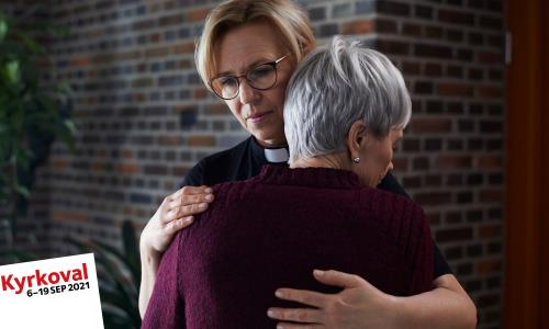 Två personer kramas. I bilden finns texten Kyrkoval 6-19 september 2021.