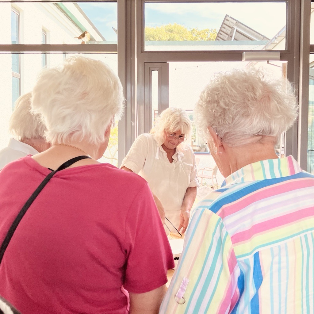 Två äldre damer väntar på att bli serverade en kopp kaffe.