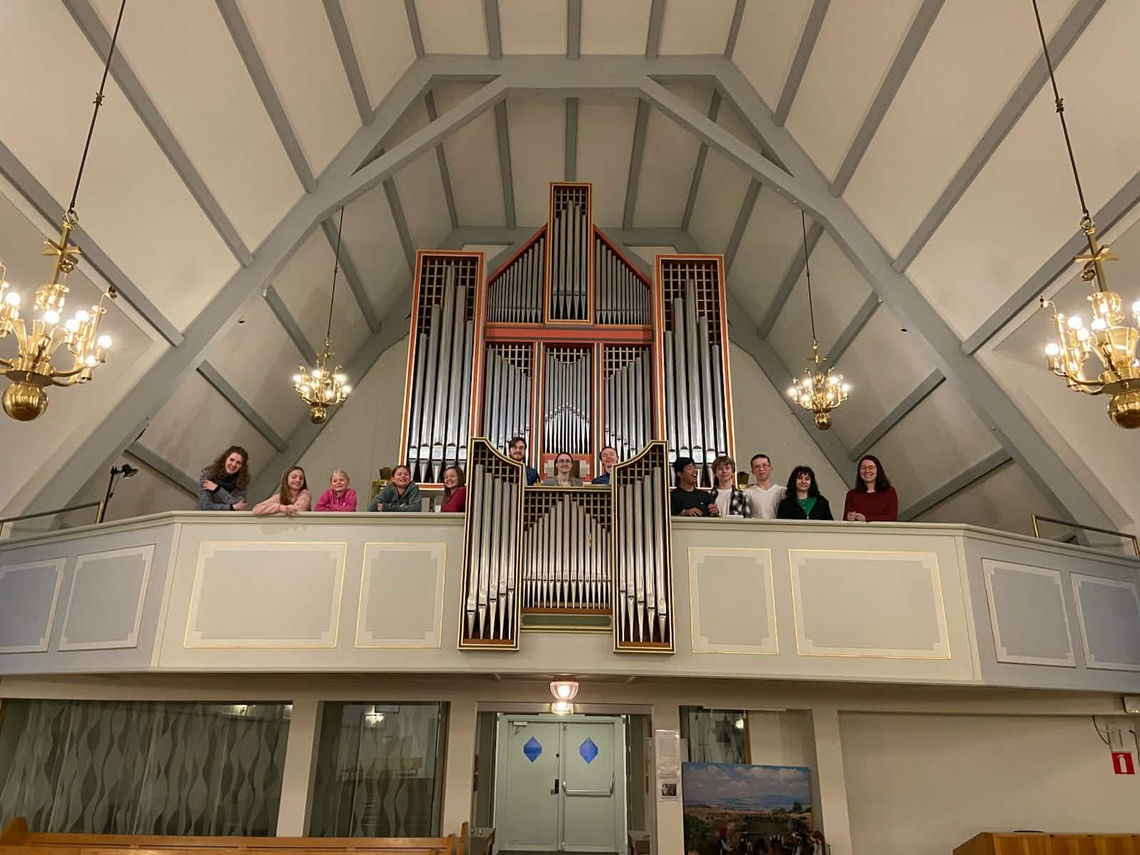 Gruppbild på elever i musikskolan som står uppe på orgelläktare.