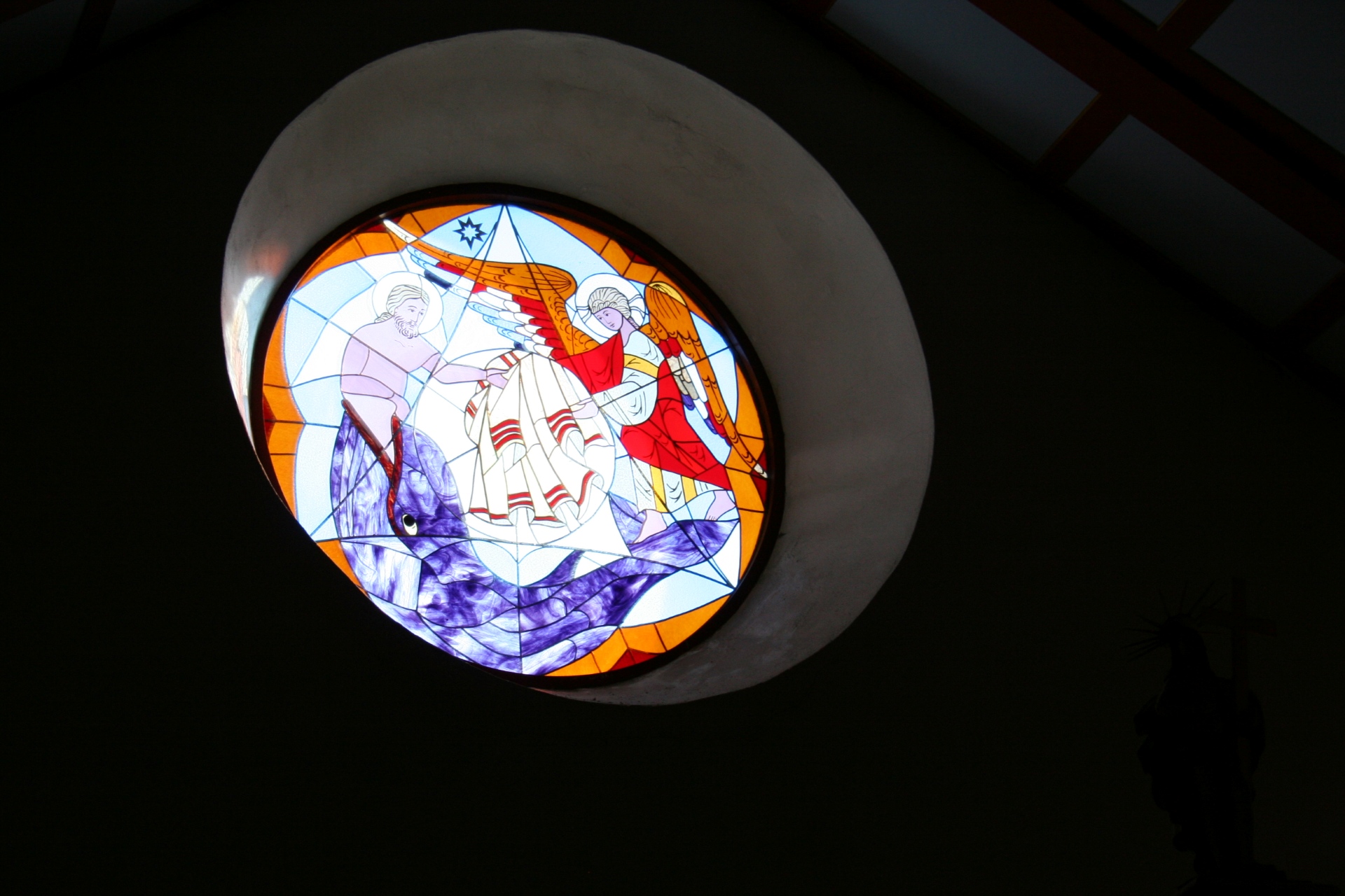 Färgglatt målat kyrkfönster i Västra Frölunda kyrka med en blåval som motiv.