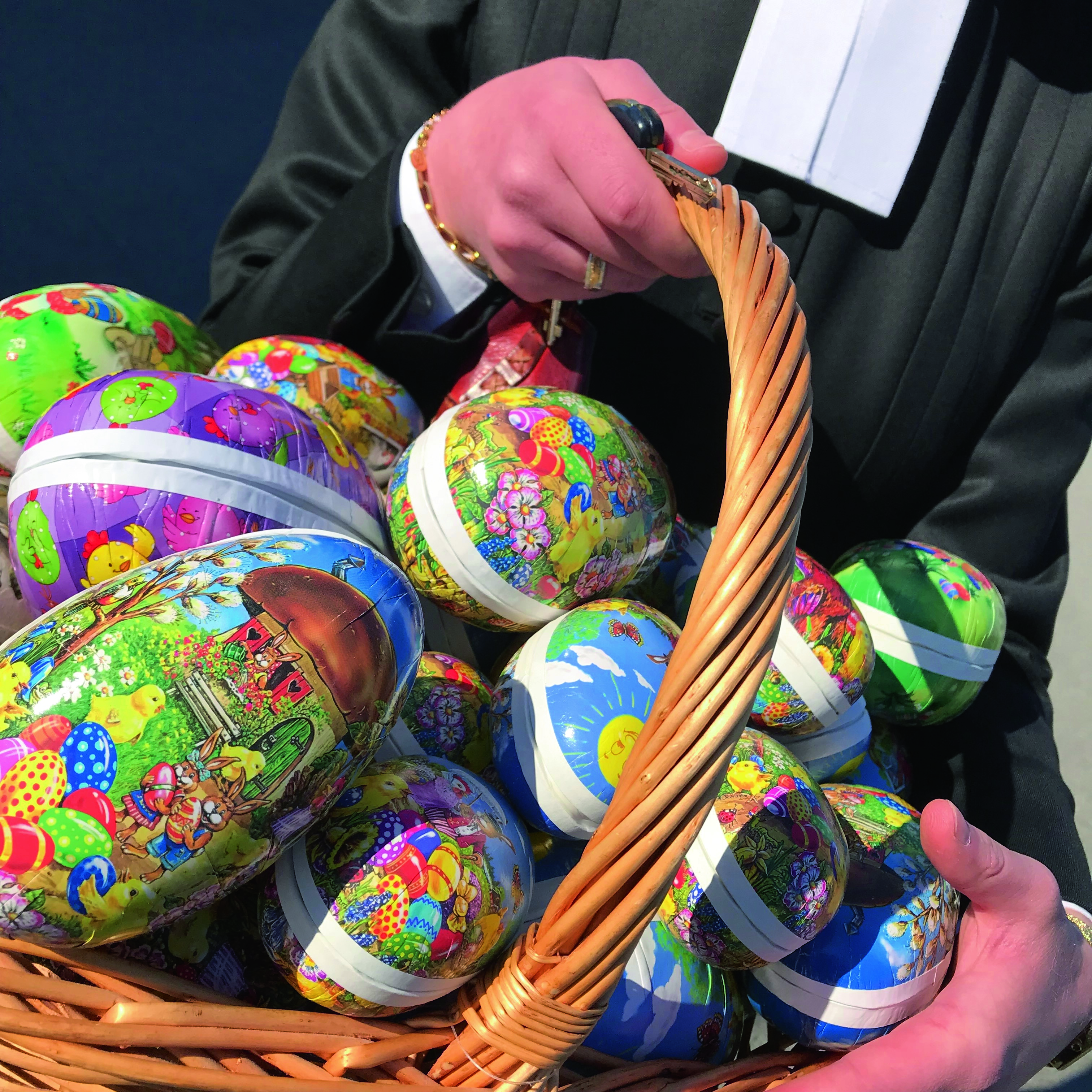 En präst håller en korg med påskägg.