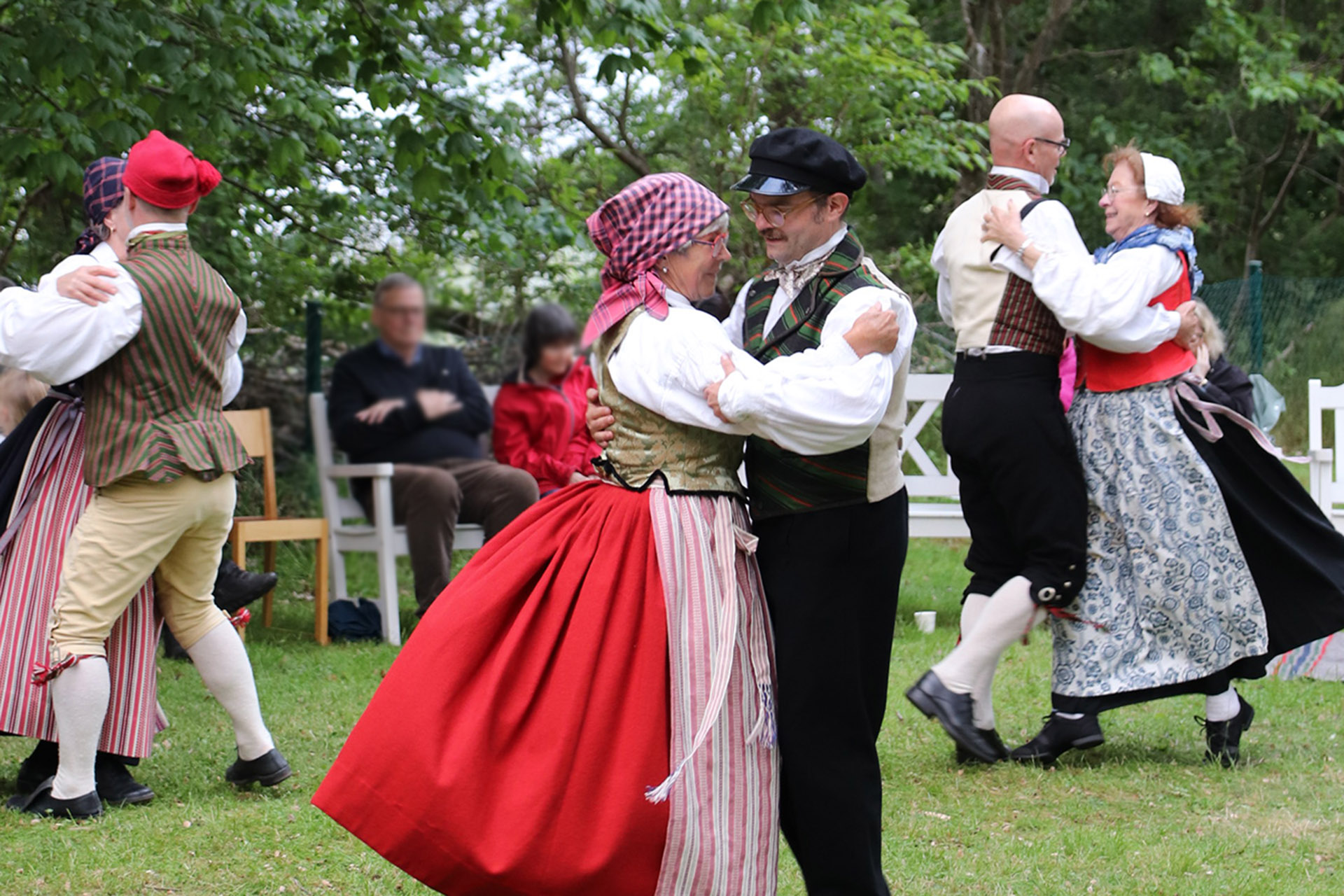Folkdanslag i folkdräkter dansar.