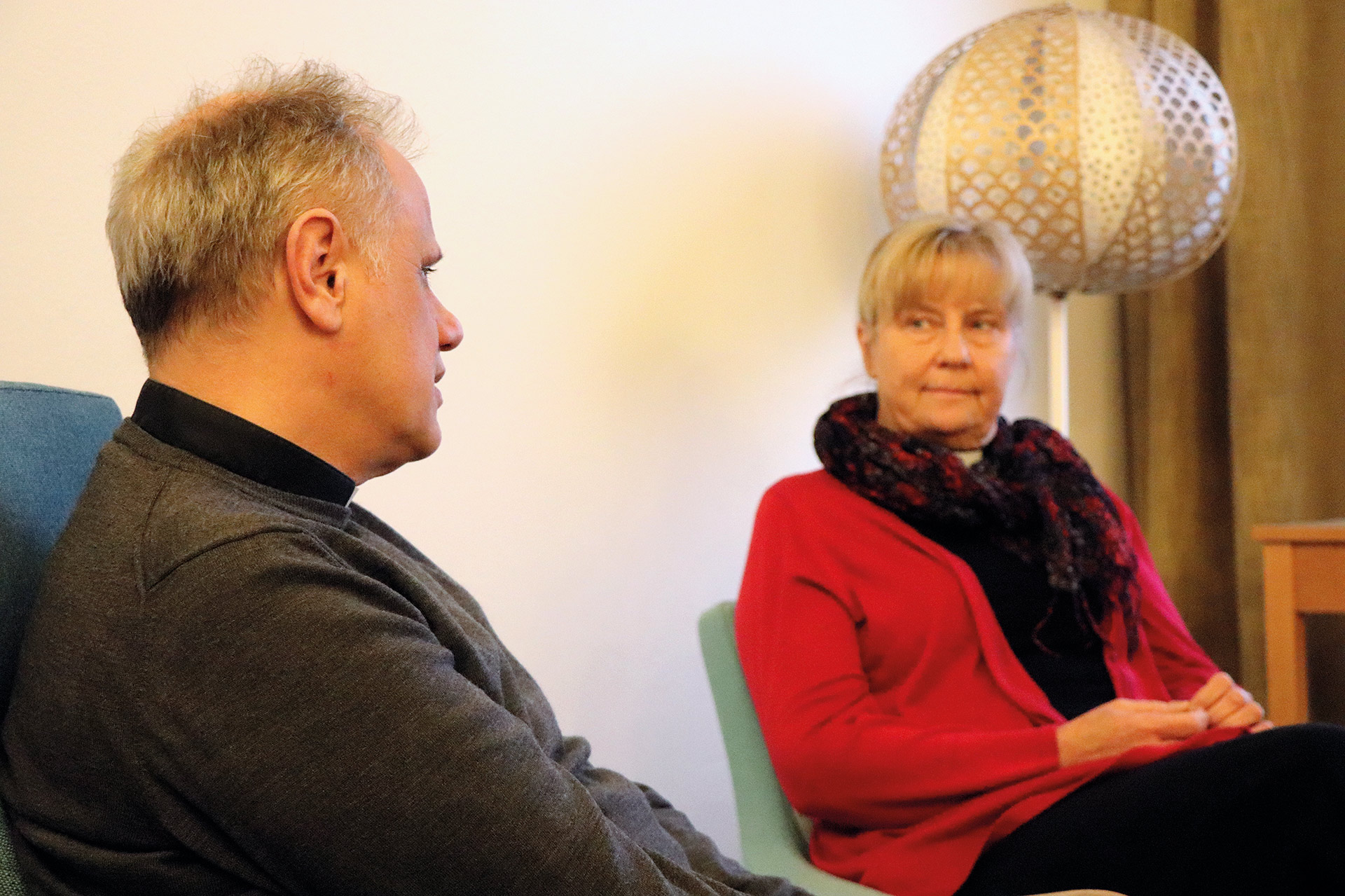 Två personer sitter vända mot varandra i samtal.