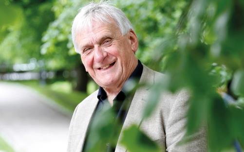 En bild på Stefan Edman i sommargrönska.