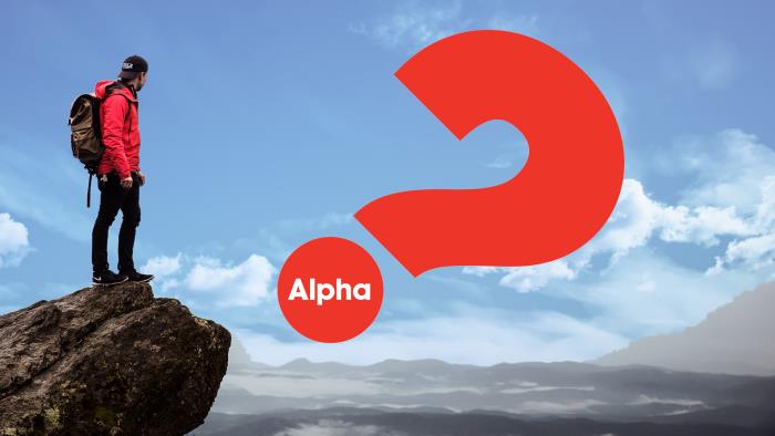 En person står på en klippa och blickar ut, ett rött frågetecken med texten "Alpha". 