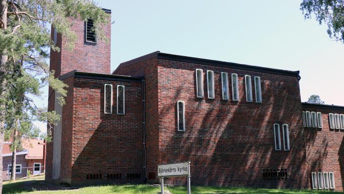 En mindre tegelkyrka fotograferad utvändigt.