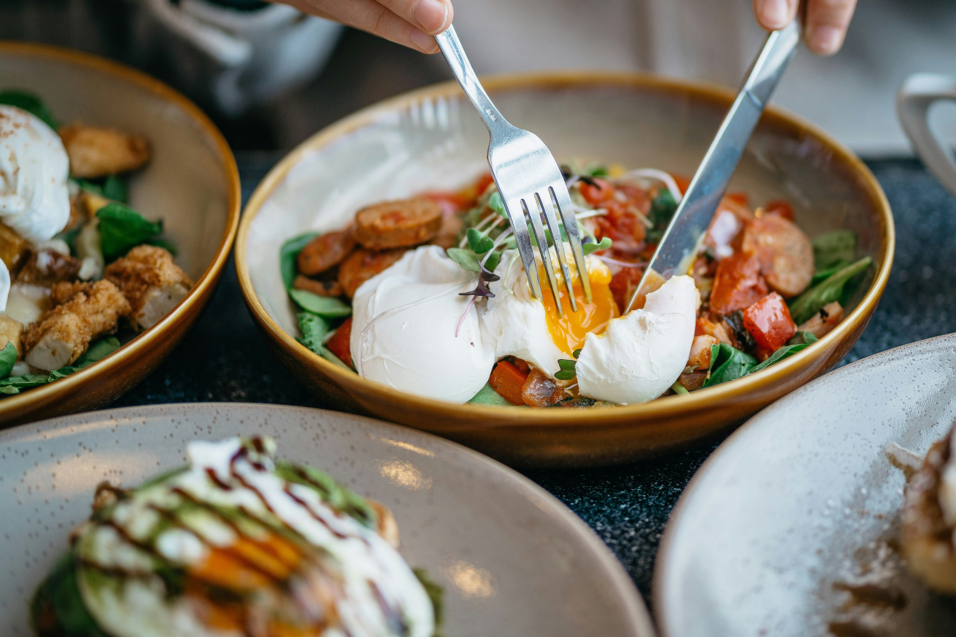 Sallad, ägg och korv m.m. serverade på tallrikar.