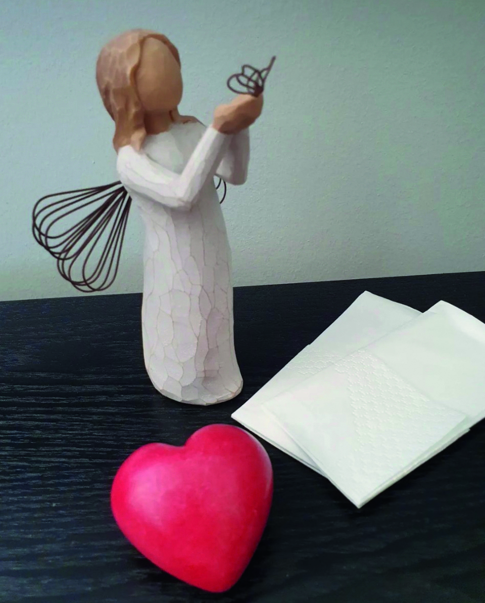 Ett hjärta, en ängel och näsdukar på ett bord. 
