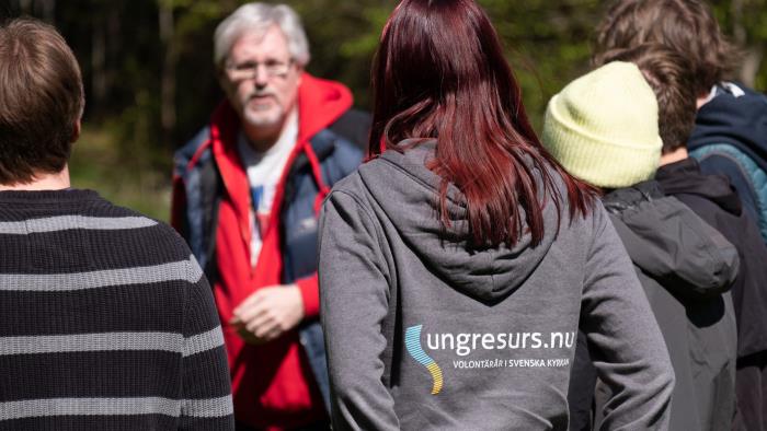 Några personer står och pratar, en person har en tröja med texten "Ung resurs" på ryggen. 