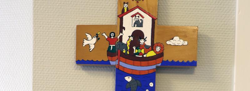 Ett kors med en bild från berättelsen om Noas ark. 