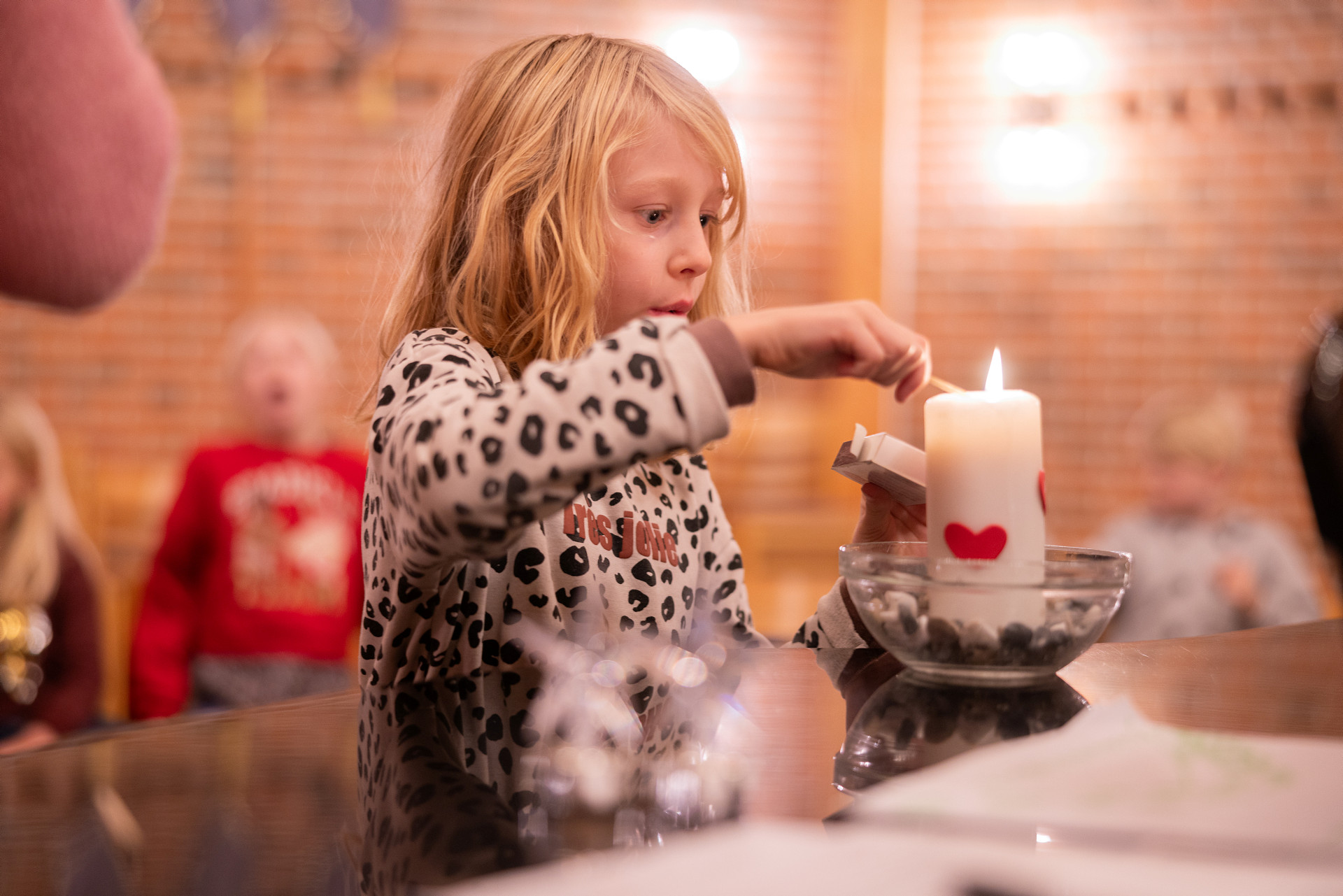 Ett barn tänder ett ljus i ett kyrkorum.