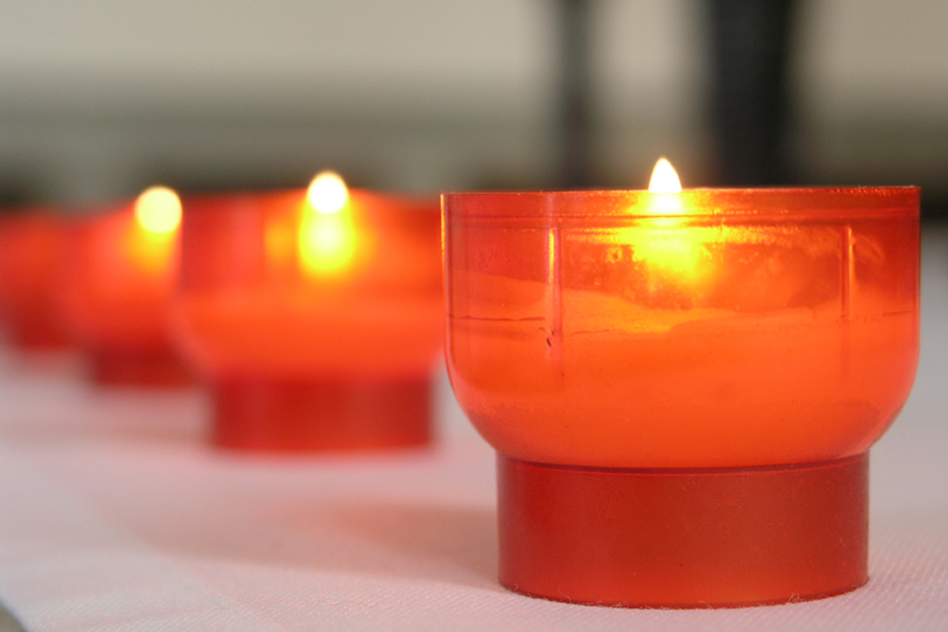 Tända ljus i röda ljuslyktor.