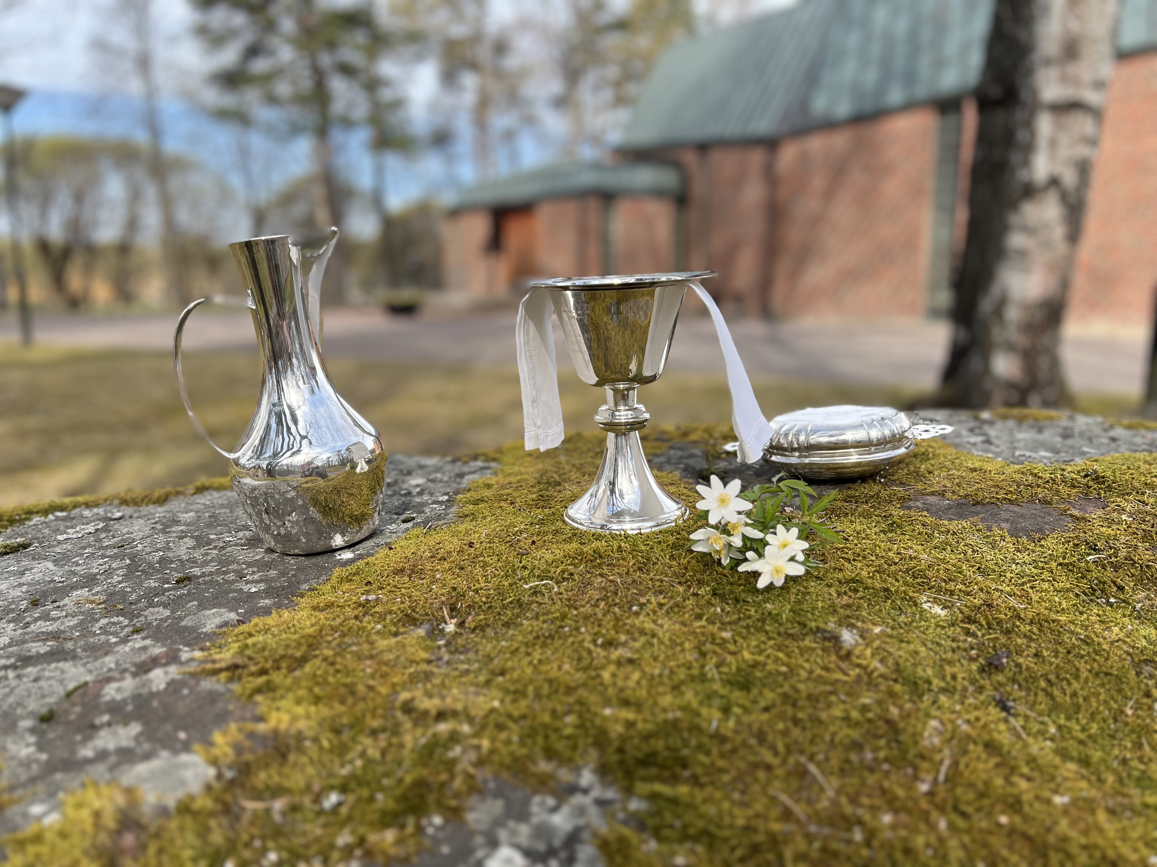 En stor mossig sten används som altare utanför Forsbacka kyrka.