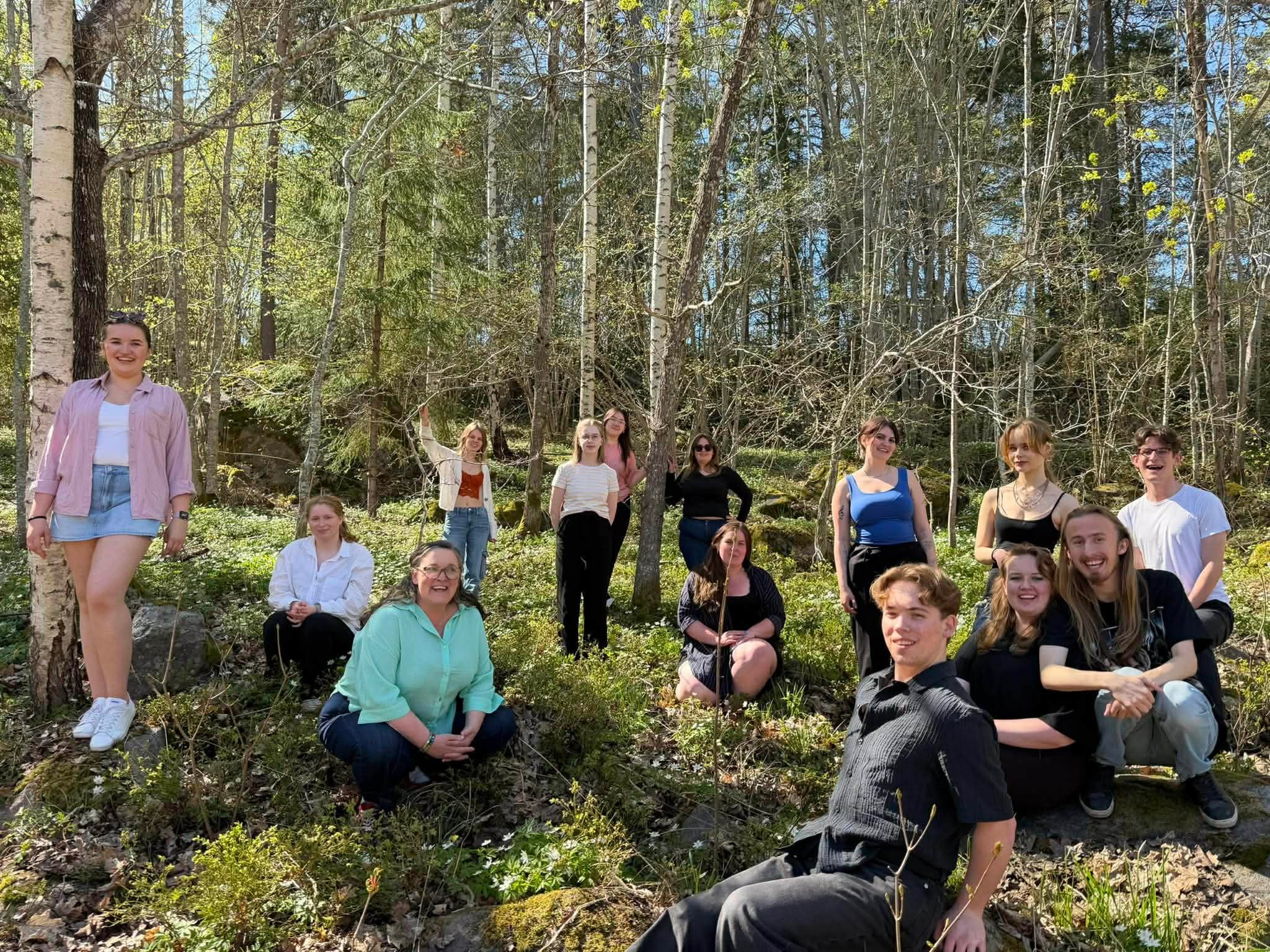 Ungdomar i en skogsbacke på våren