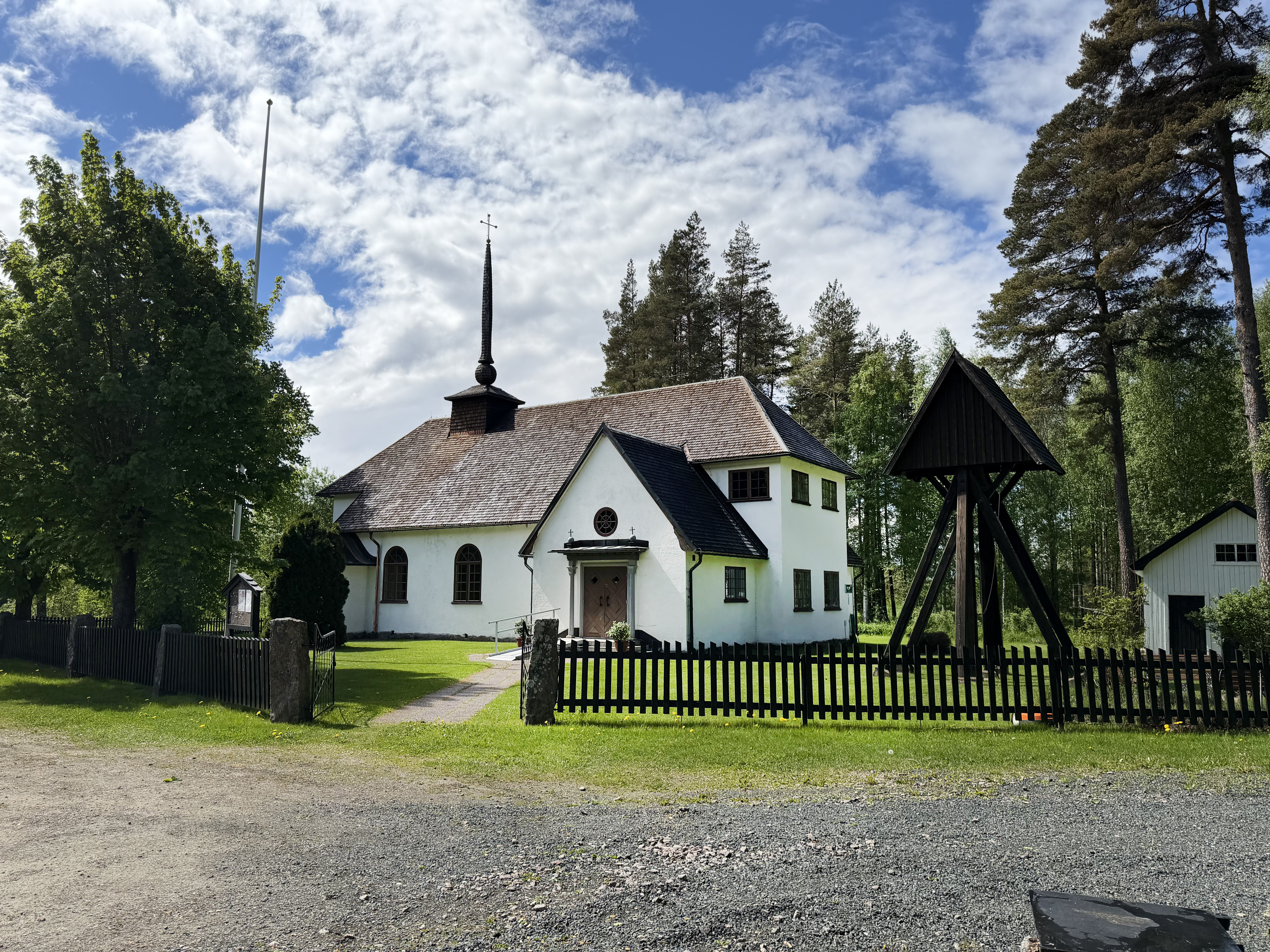 Den lilla vita Ansgariikyrkan inbäddad i grönska.