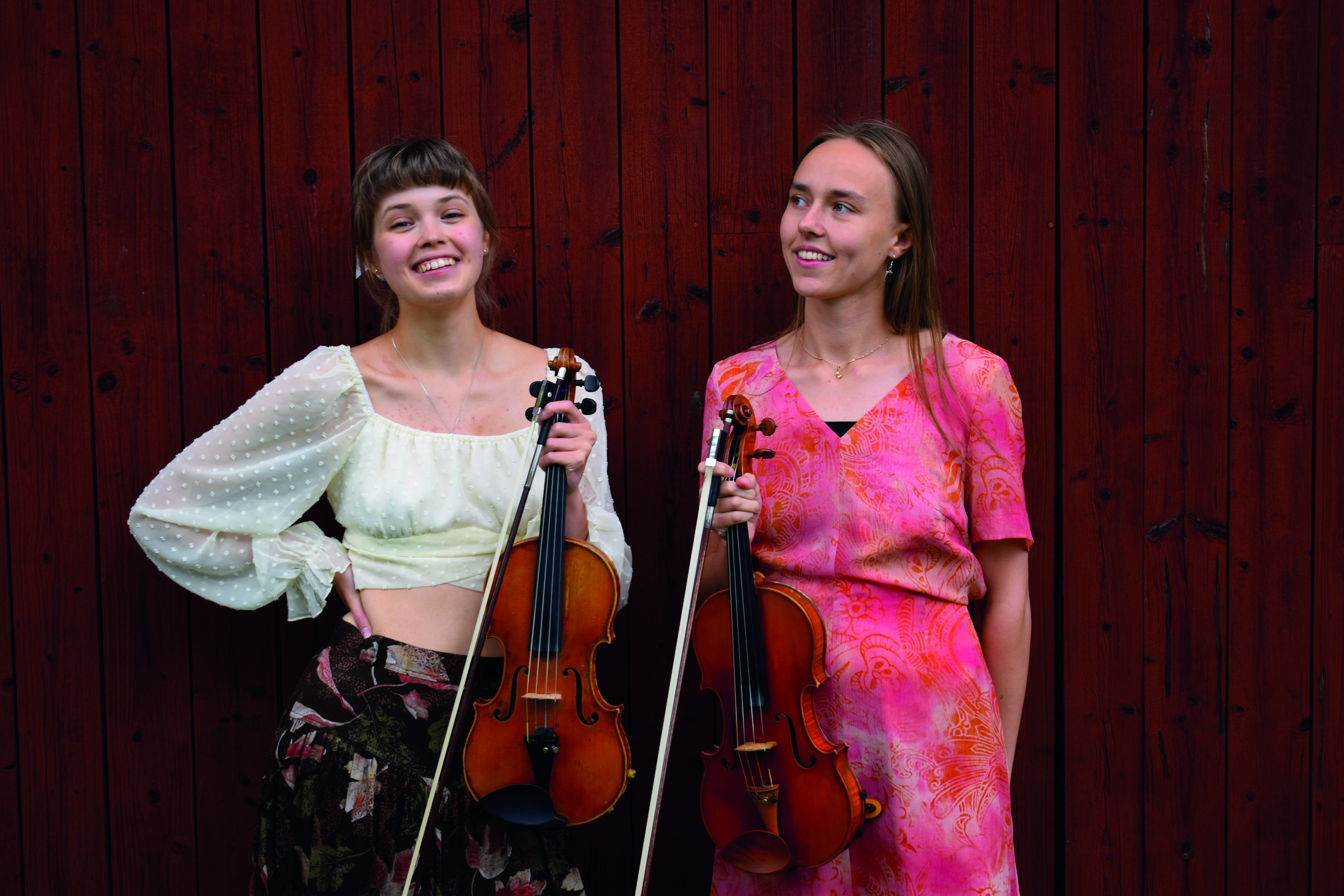 Elsa och Alma spelar folklig musik i midsommartid.