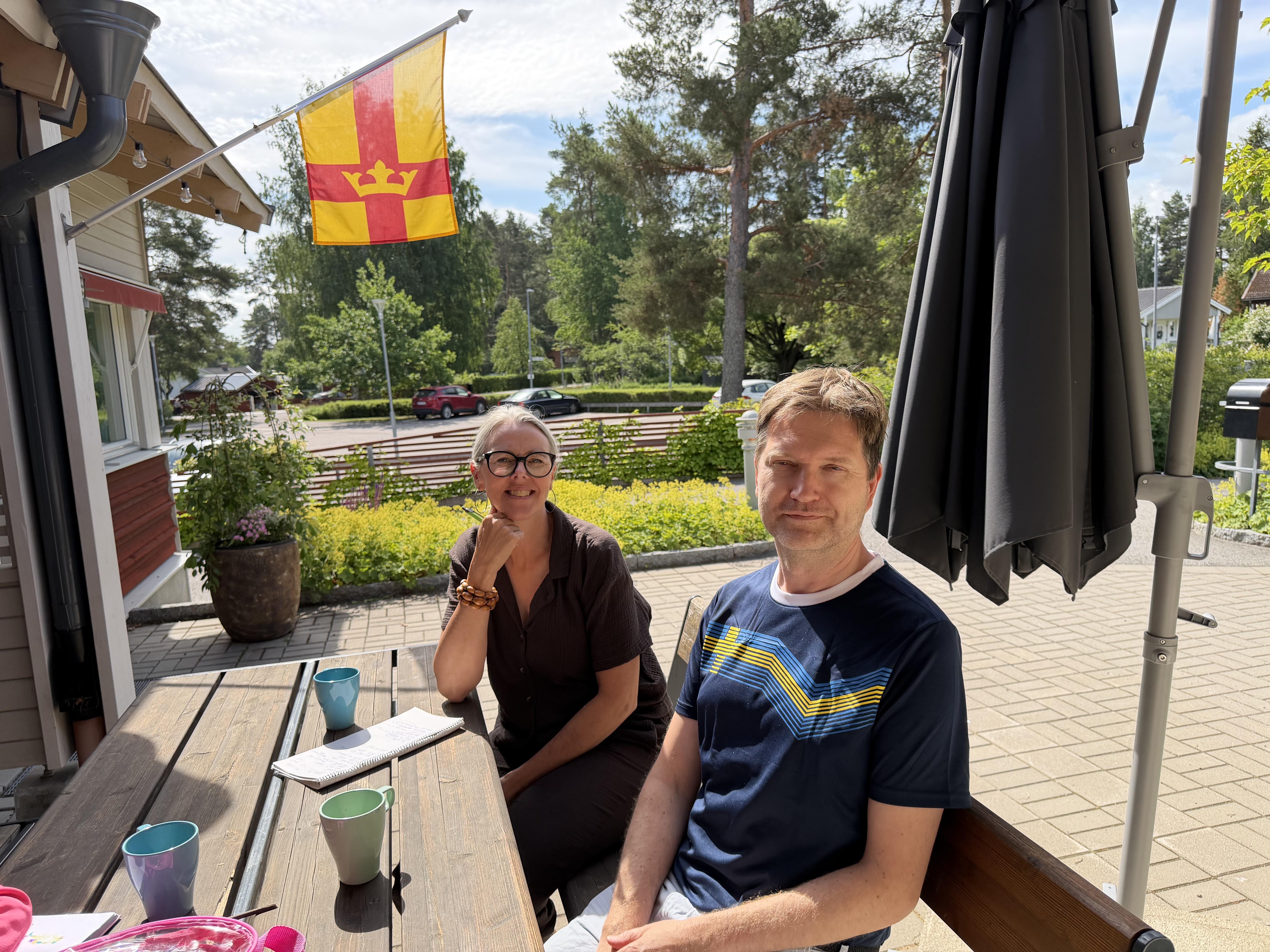 Sarah och Niklas sitter och pratar vid ett bord utomhus