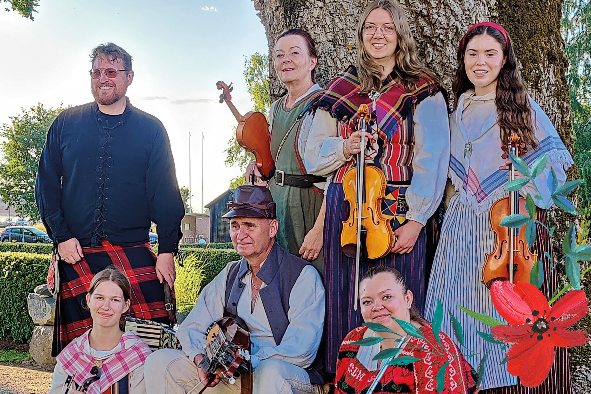 Gruppen Tierps låtverkstad i gröngrässet klädda i folkdräkter och med sina instrument i handen.