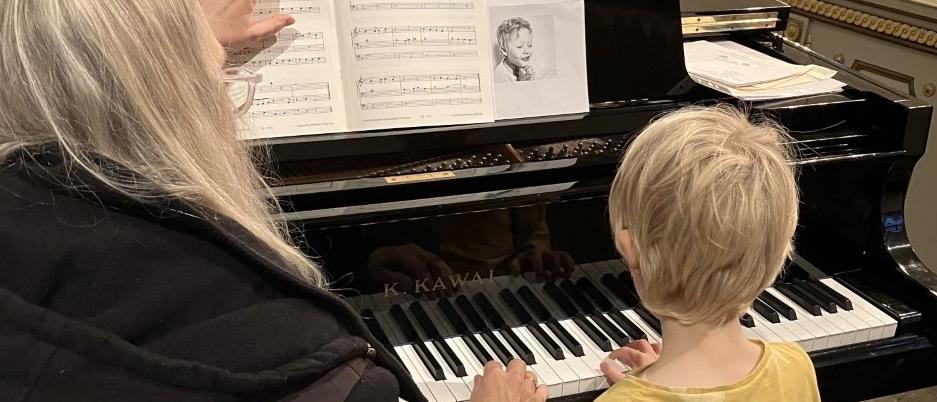 Pianolärare undervisar elev vid flygel