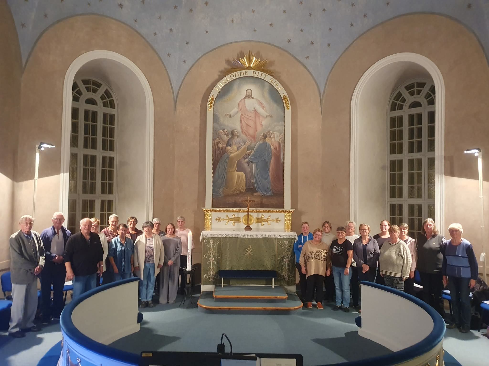 Körsångare uppställda framme i koret i Vibyggerå kyrka