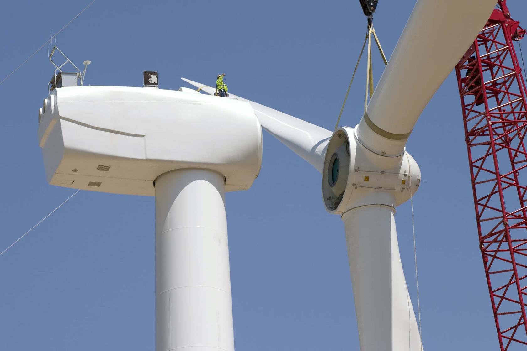 En person som arbetar högt upp på ett vindkraftverk.