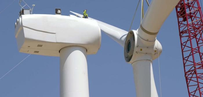 En person som arbetar högt upp på ett vindkraftverk.