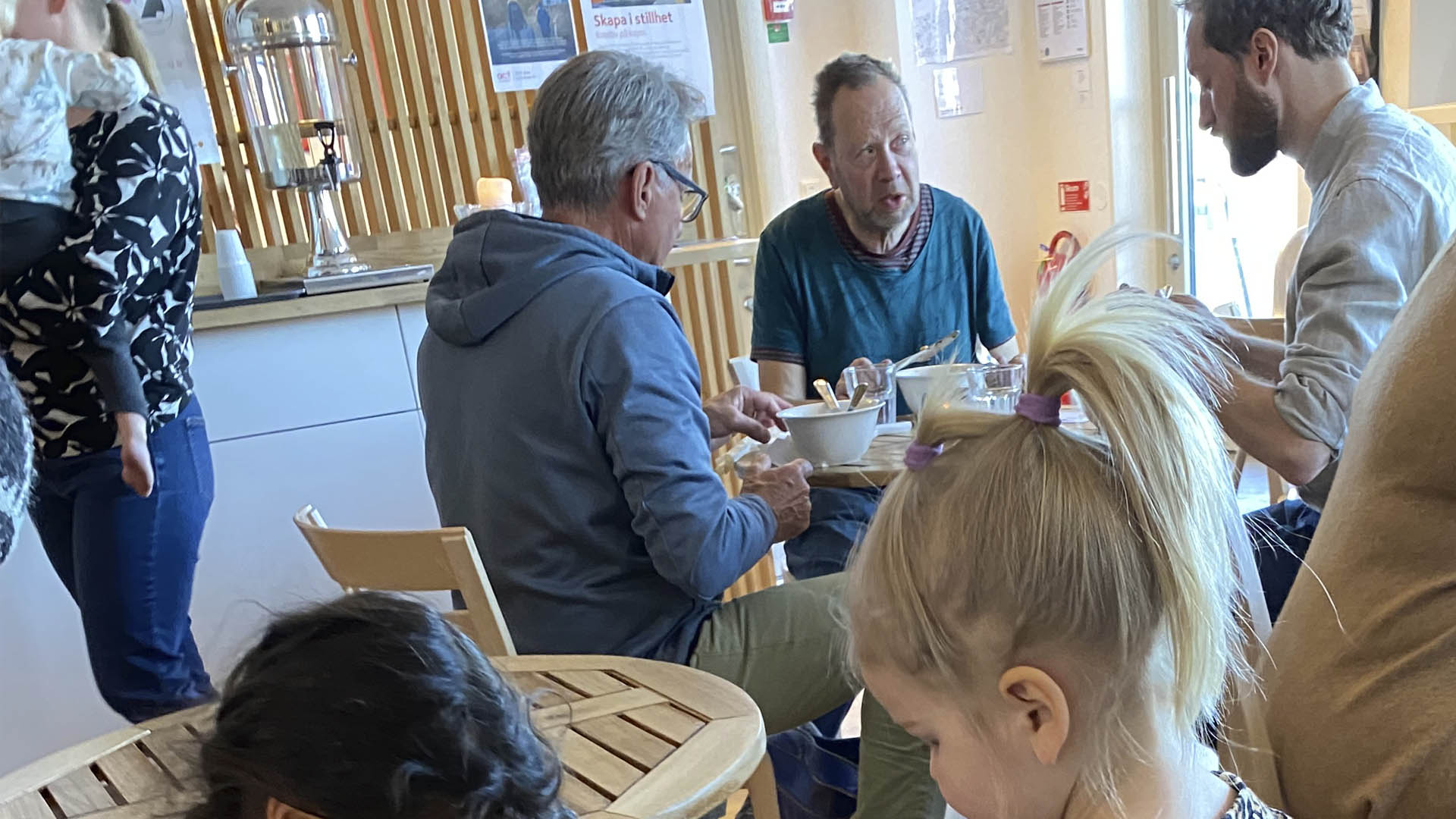 människor vid cafébord i Kvarterskyrkan på kajen