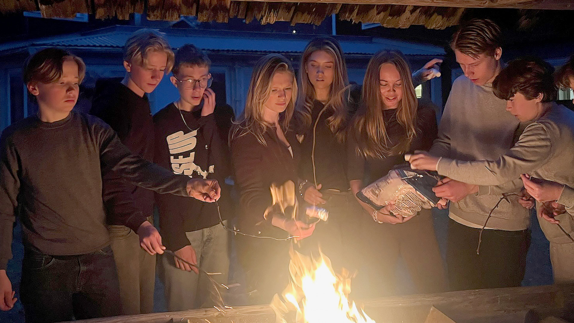 Konfirmationsungdomar grillar marshmallows.