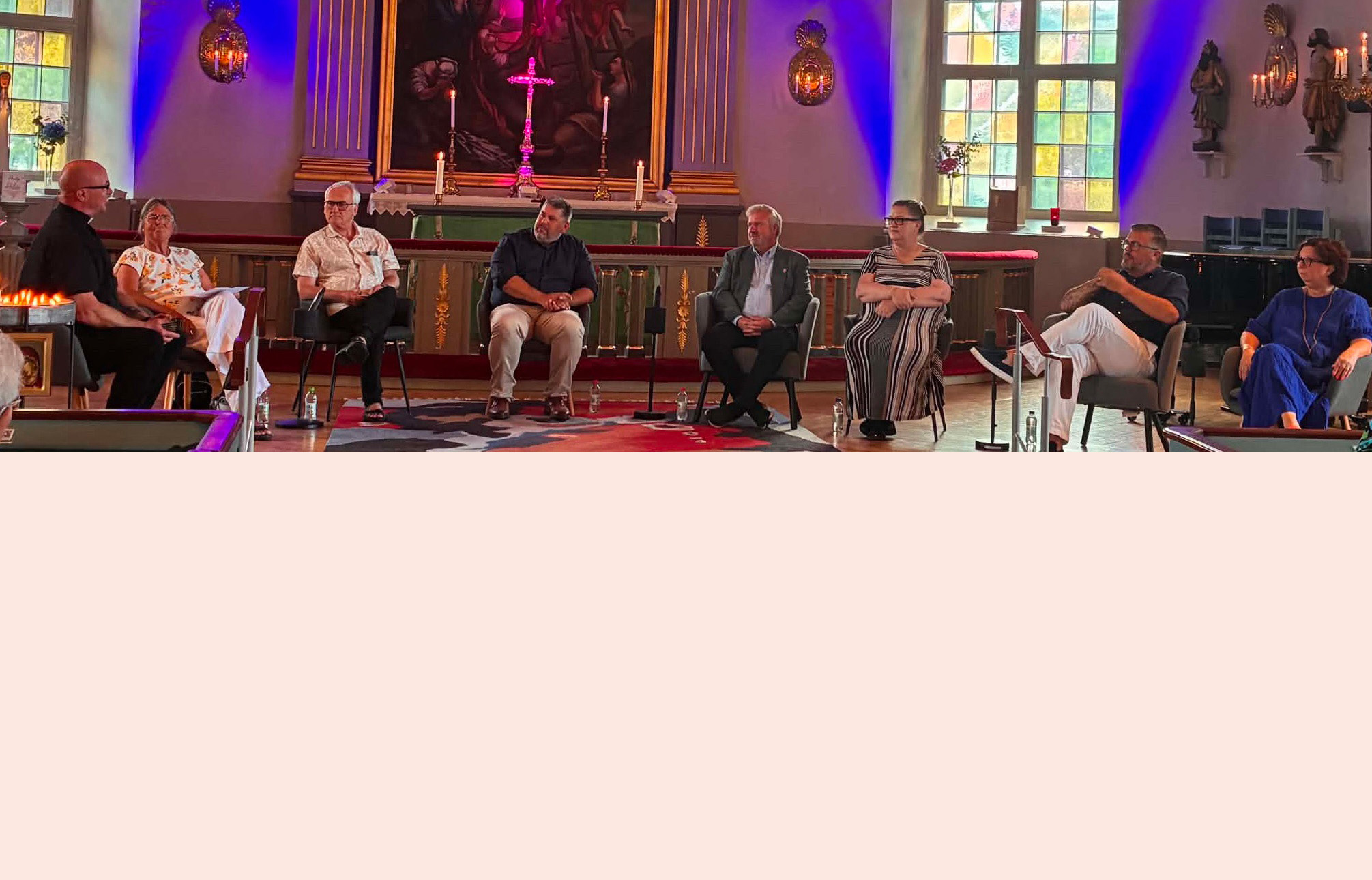 Representanter för de politiska partierna i Mönsterås kommun sitter på rad på varsin stol i koret i Mönsterås kyrka.